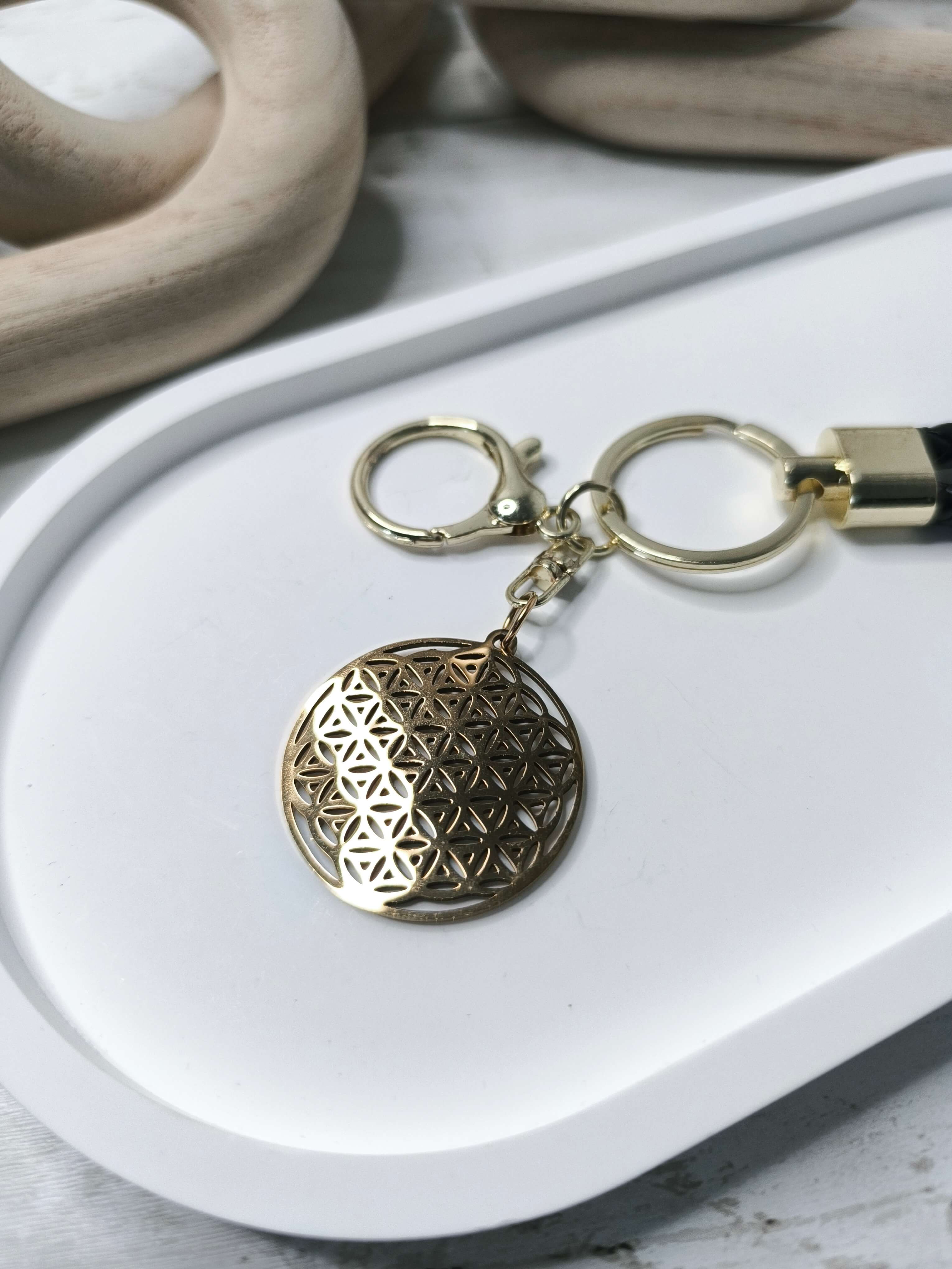 PORTE CLES FLEUR DE VIE EN ACIER INOXYDABLE - DORE - GEOMETRIE SACREE & CORDON TRESSE NOIR