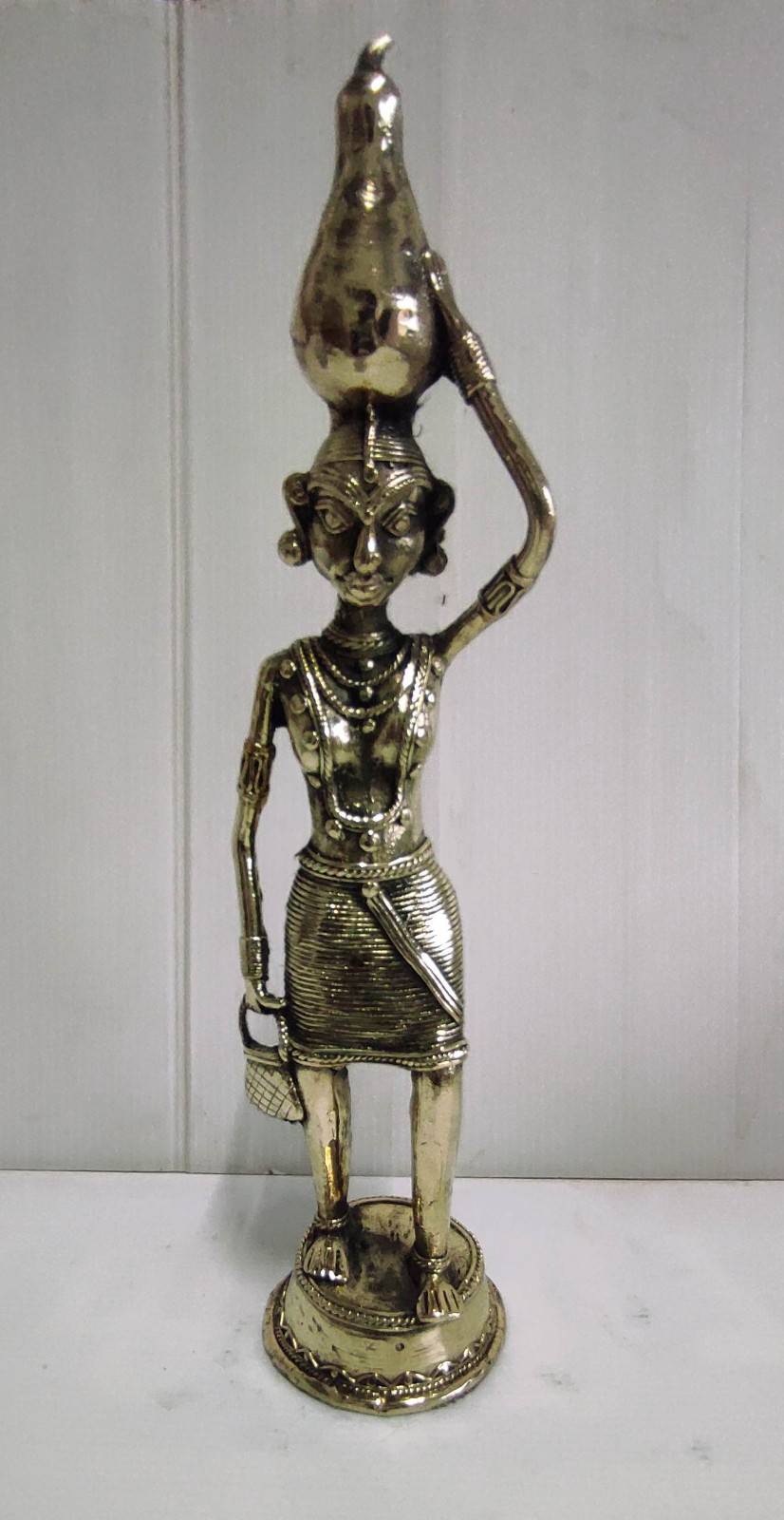 Brass Tribal Woman in Traditional Attire Holding a Tumba