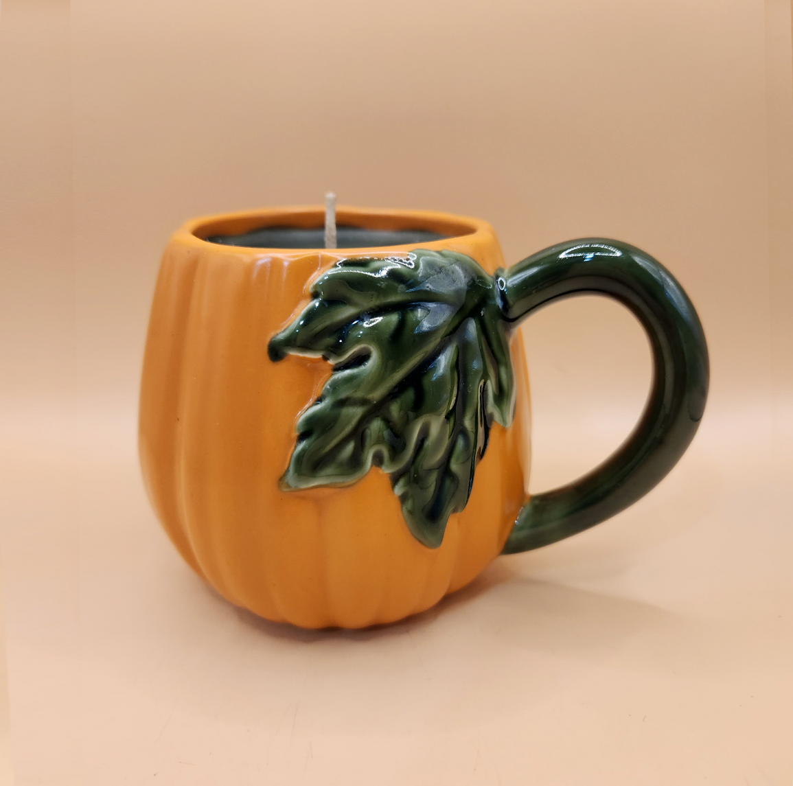 Pumpkin-shaped ceramic mug candle