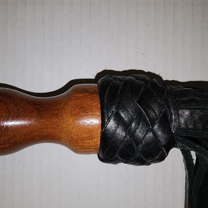 Black bullhide leather with a rosewood handle flogger