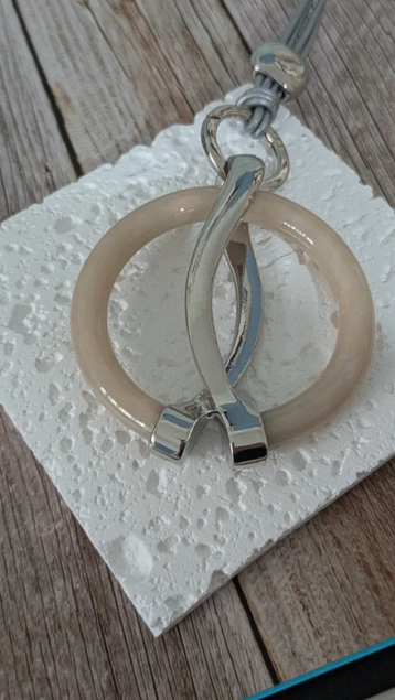 Collana con cordino multifilo argentato e pendente in resina