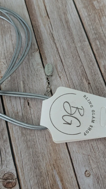 Collana con cordino multifilo argentato e pendente in resina