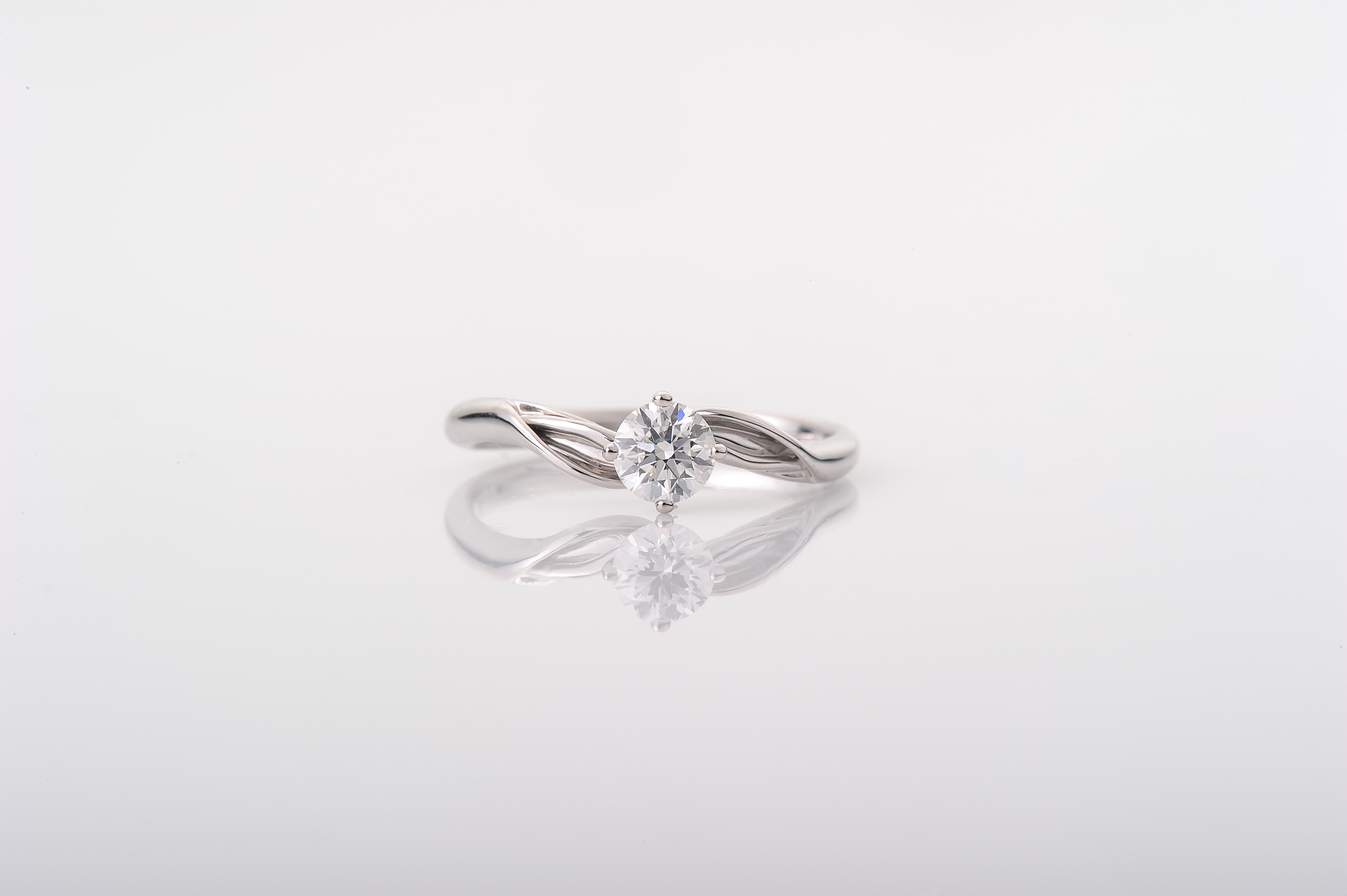 Elegantly twisted White Gold Ring with solitaire diamond