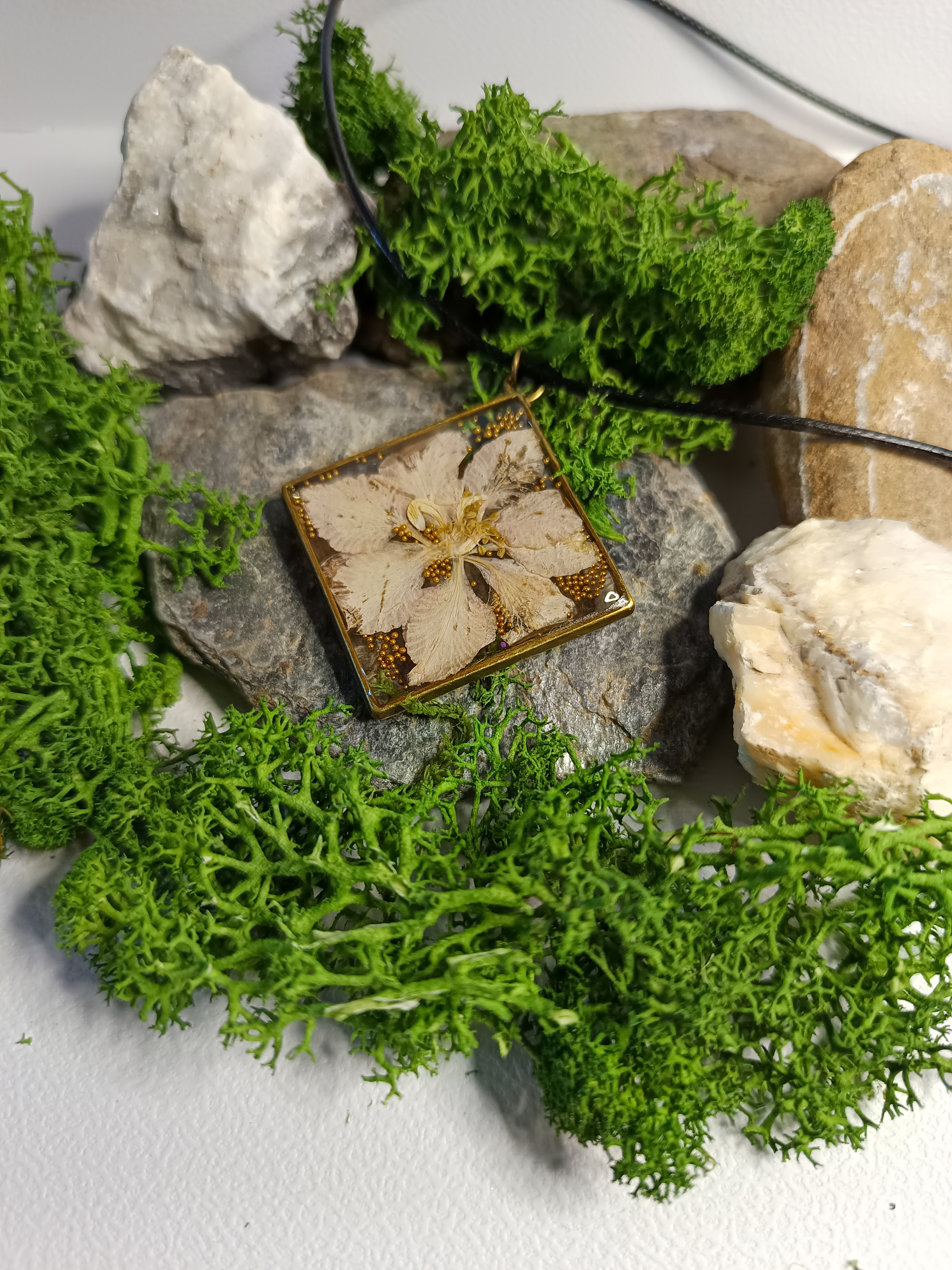 Pendentif en résine avec fleur séchée