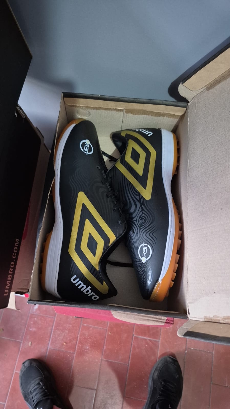 Chuteira Umbro society/sintético preta dourada