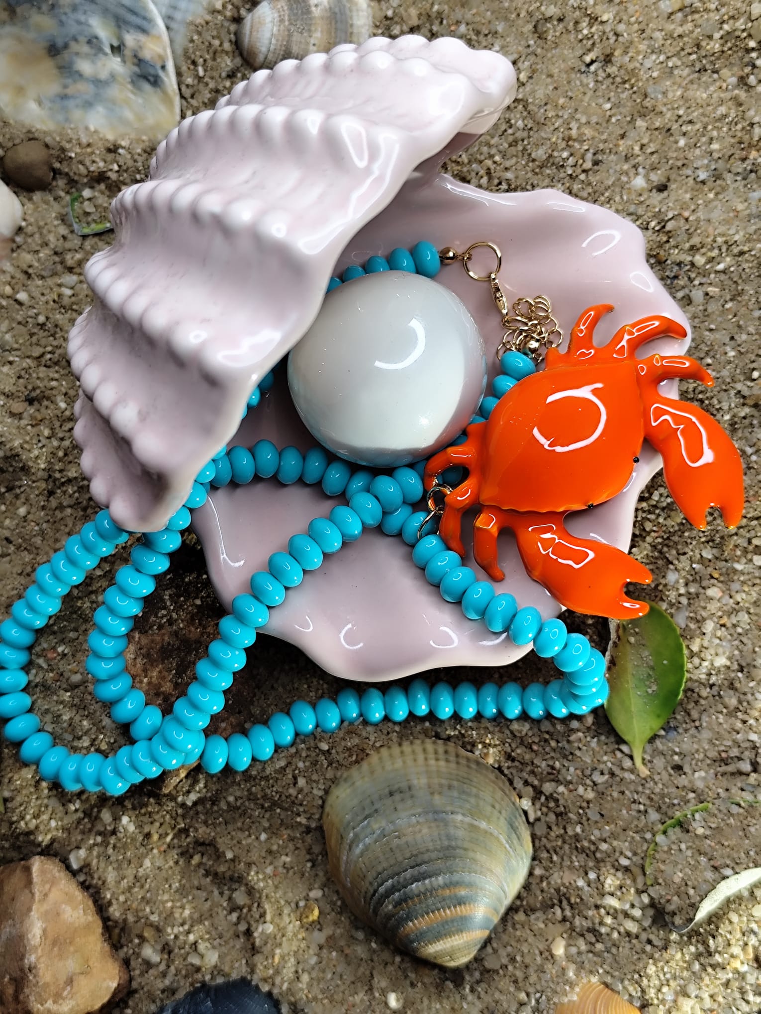 Collar de cuentas turquesas con cangrejo naranja 