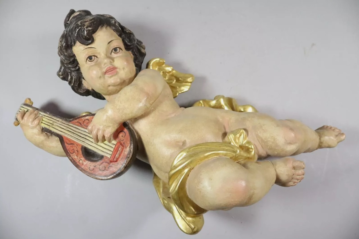 Figura de querubín en madera tallada y policromado con instrumento musical