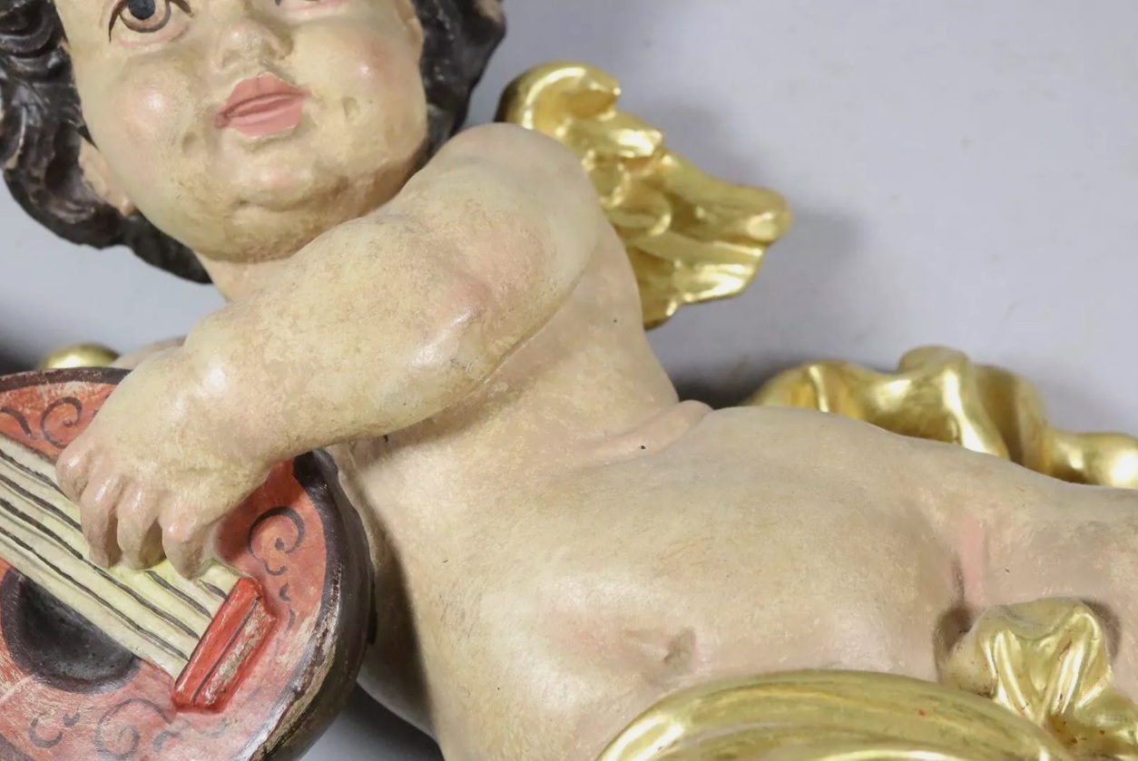Figura de querubín en madera tallada y policromado con instrumento musical