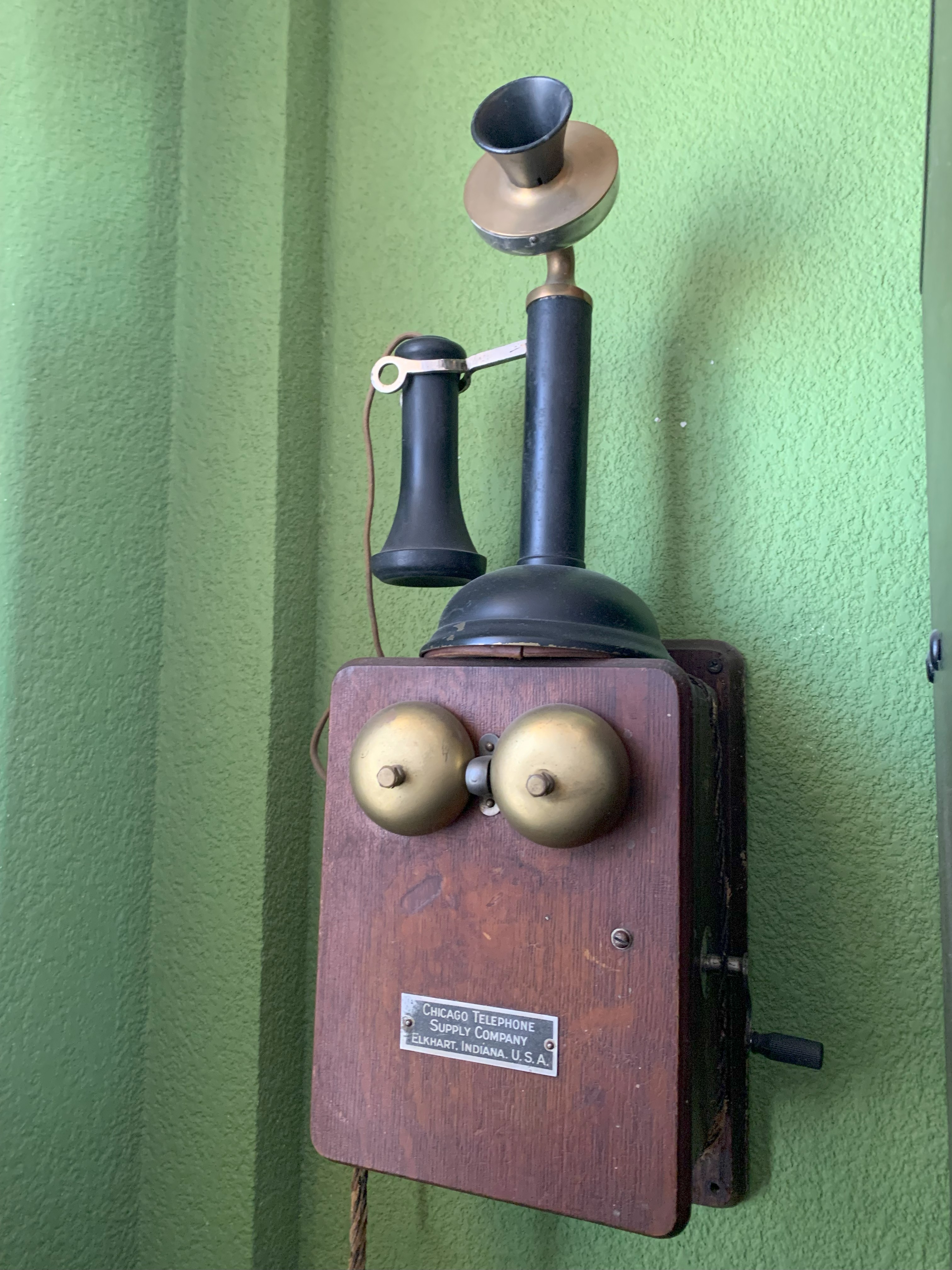 Antiguo teléfono de pared estilo candelero