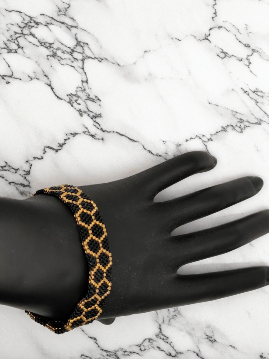 Bracelet tissé avec 800 perles noires et dorées .