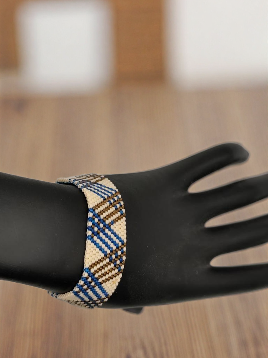 Bracelet tissé avec 1120 perles bleues crème et bronze .