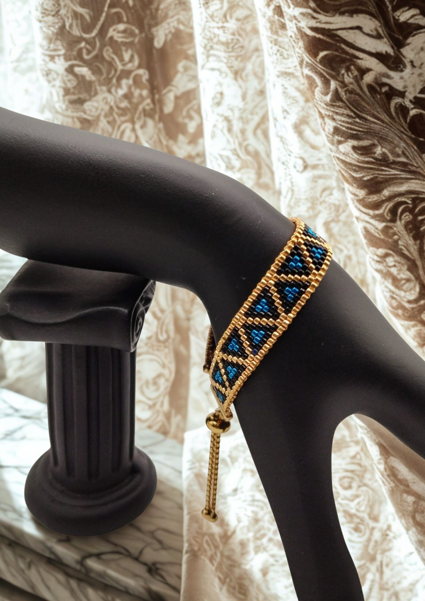 Bracelet tissé avec 640 perles dorées noires et bleues .