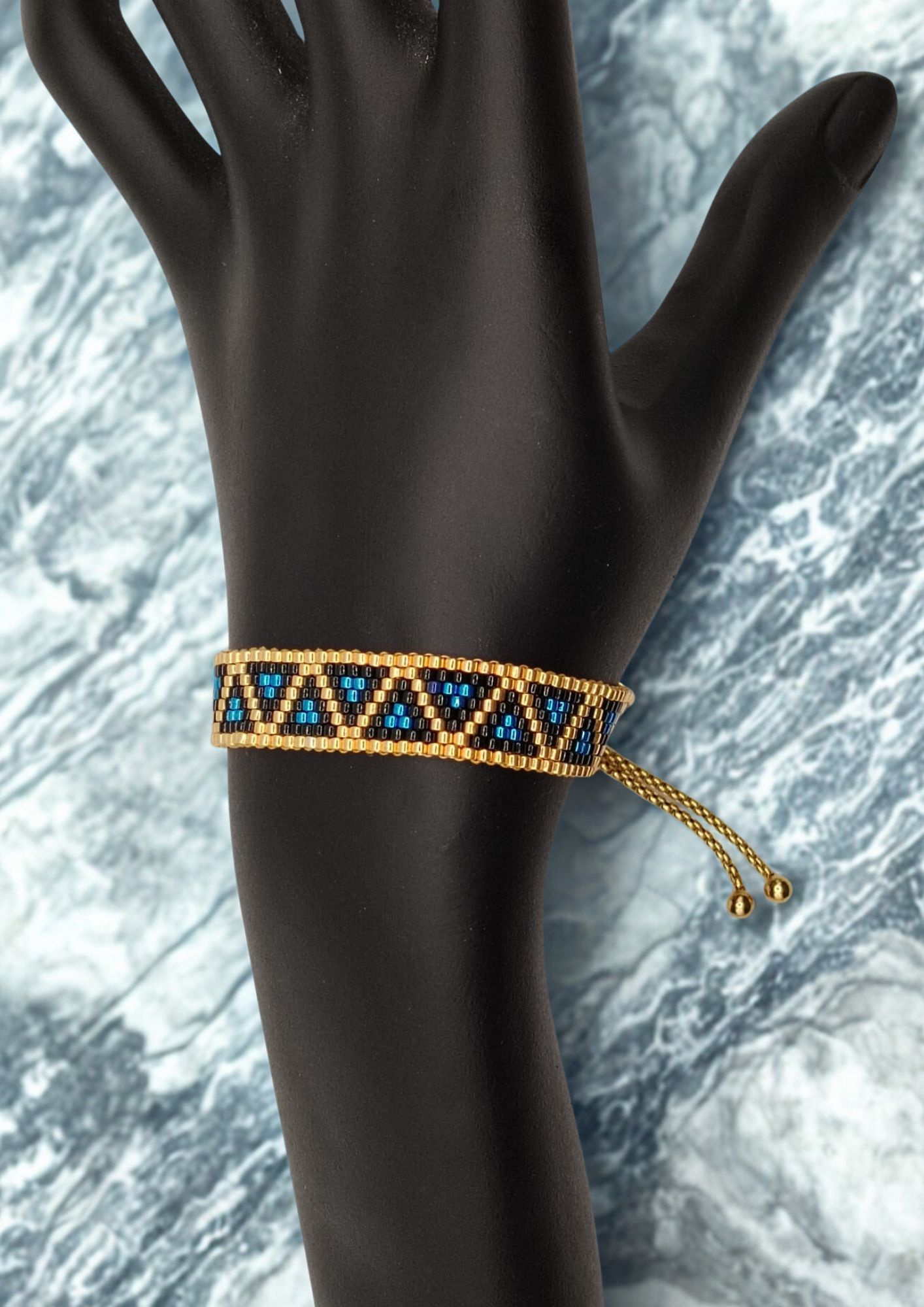 Bracelet tissé avec 640 perles dorées noires et bleues .