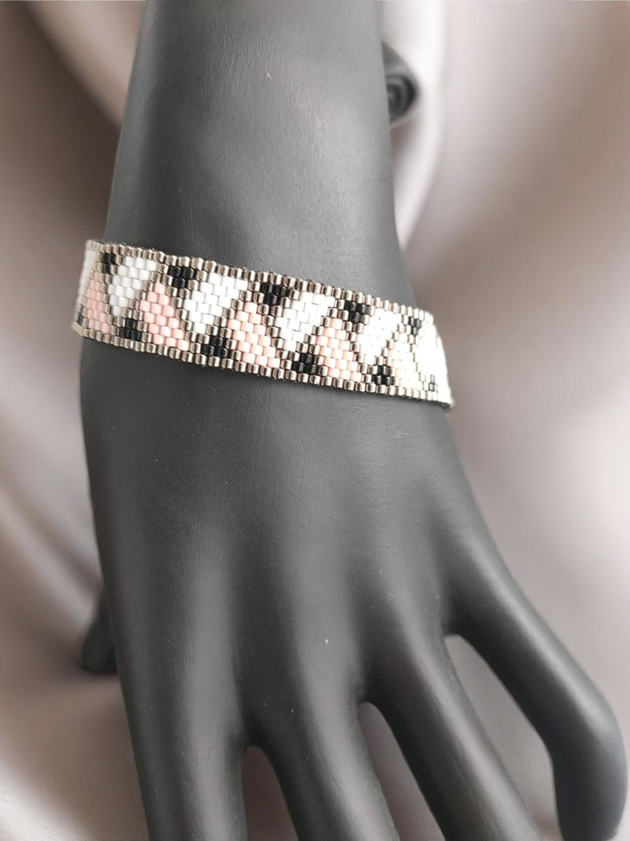 Bracelet tissé avec 800 perles argentées roses et noires .
