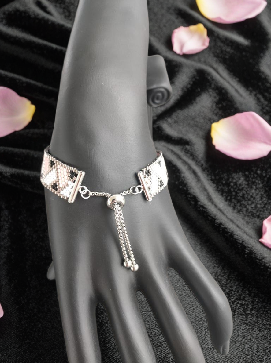 Bracelet tissé avec 800 perles argentées roses et noires .