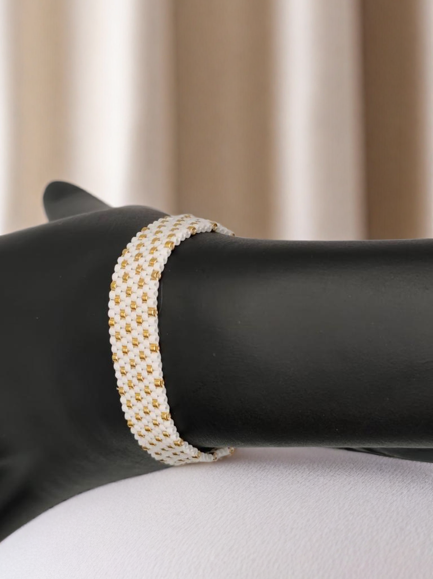 Bracelet tissé avec 640 perles blanches et dorées .