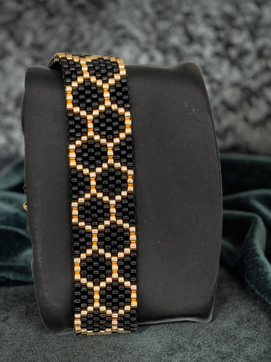 Bracelet tissé avec 800 perles noires et dorées .