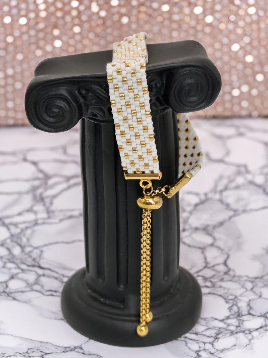 Bracelet tissé avec 640 perles blanches et dorées .