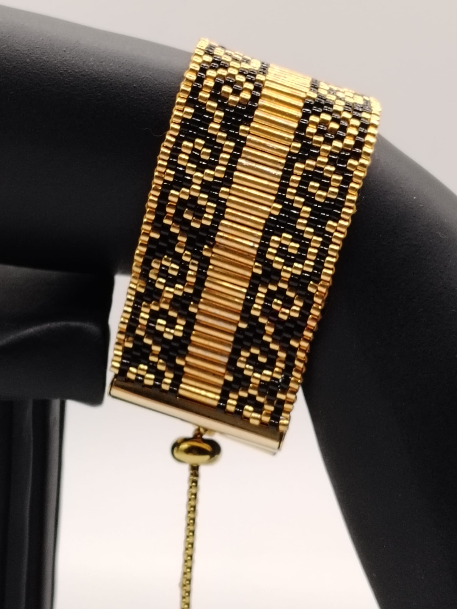 Bracelet tissé avec 1360 perles noires et dorées .