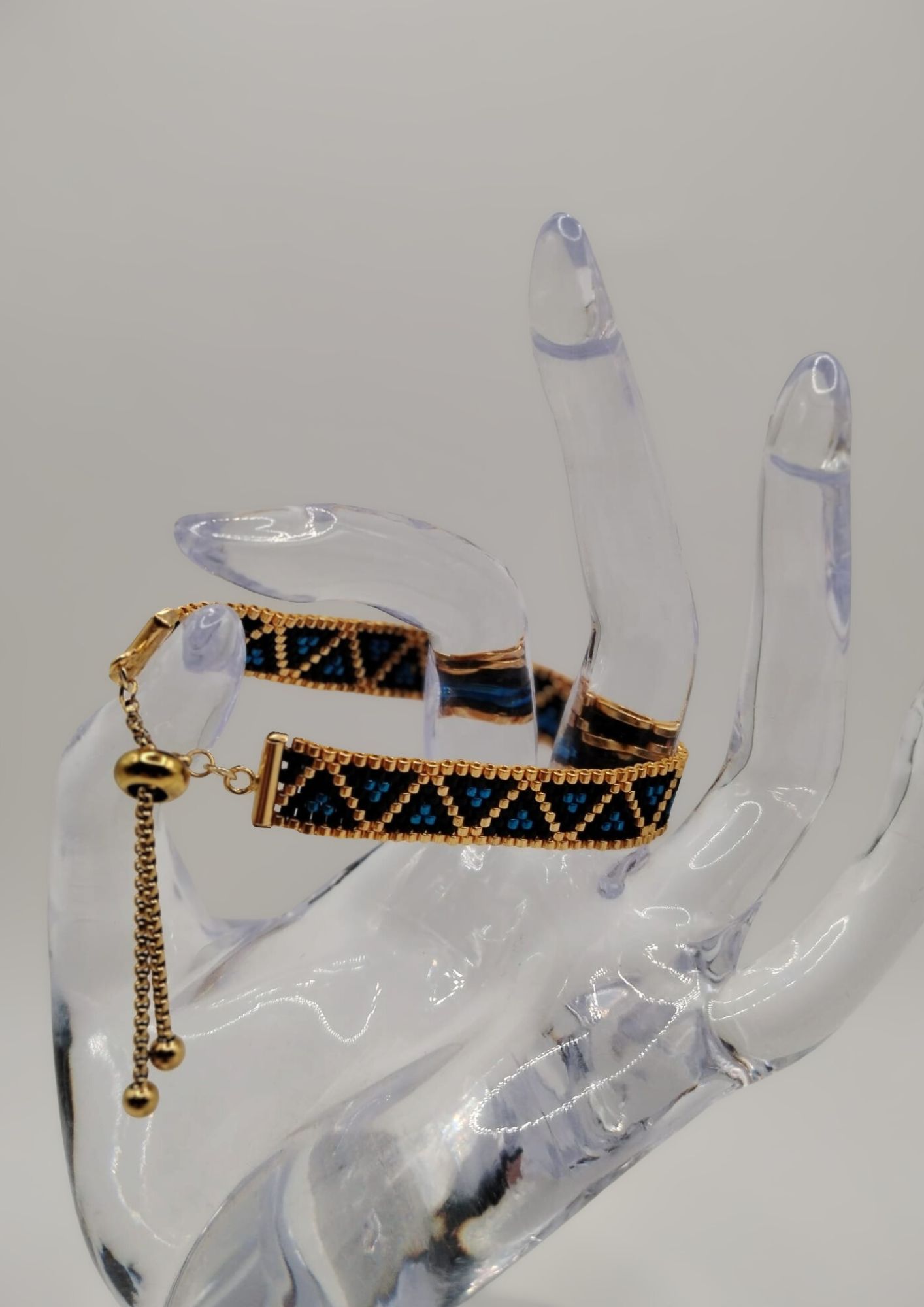 Bracelet tissé avec 640 perles dorées noires et bleues .