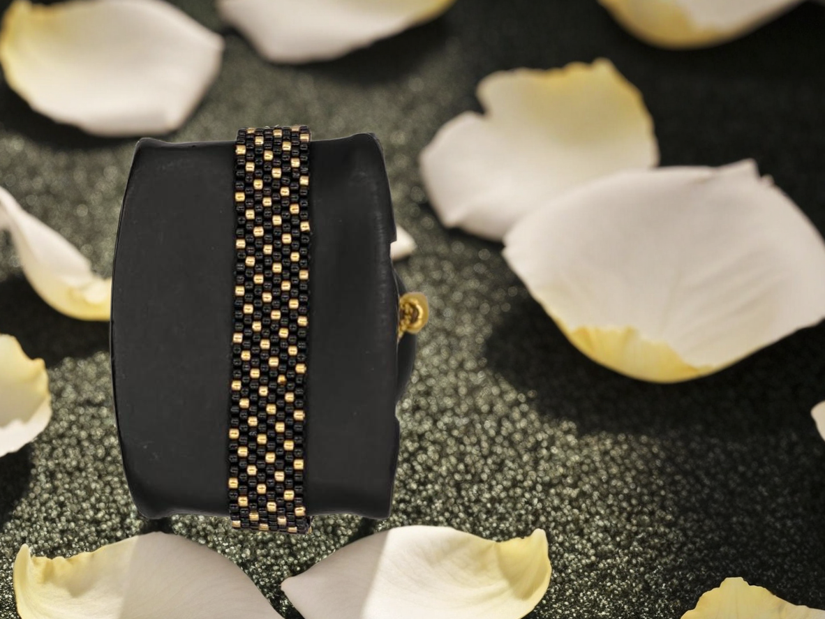 Bracelet tissé avec 640 perles noires et dorées .