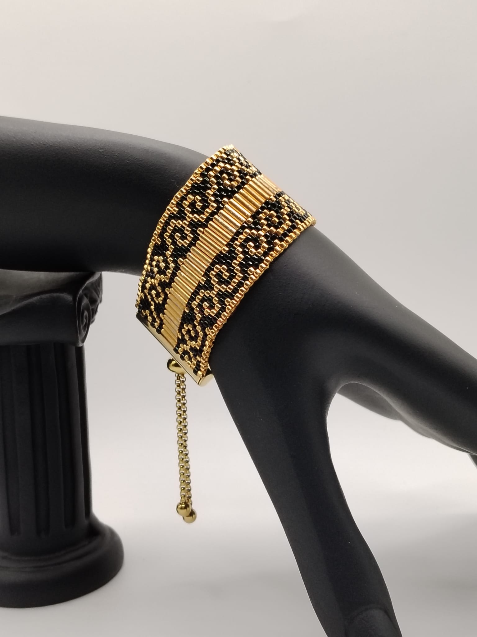 Bracelet tissé avec 1360 perles noires et dorées .