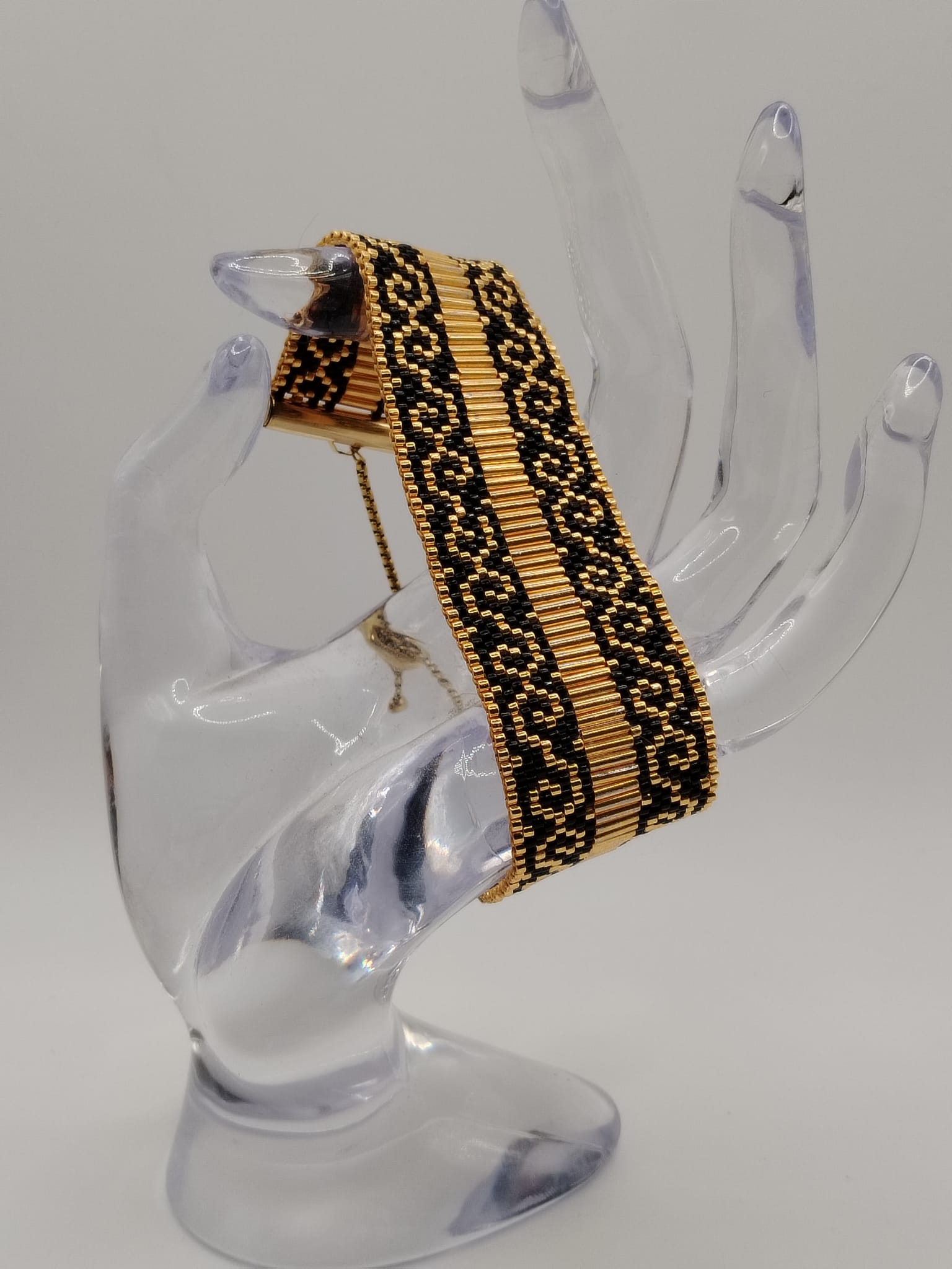 Bracelet tissé avec 1360 perles noires et dorées .