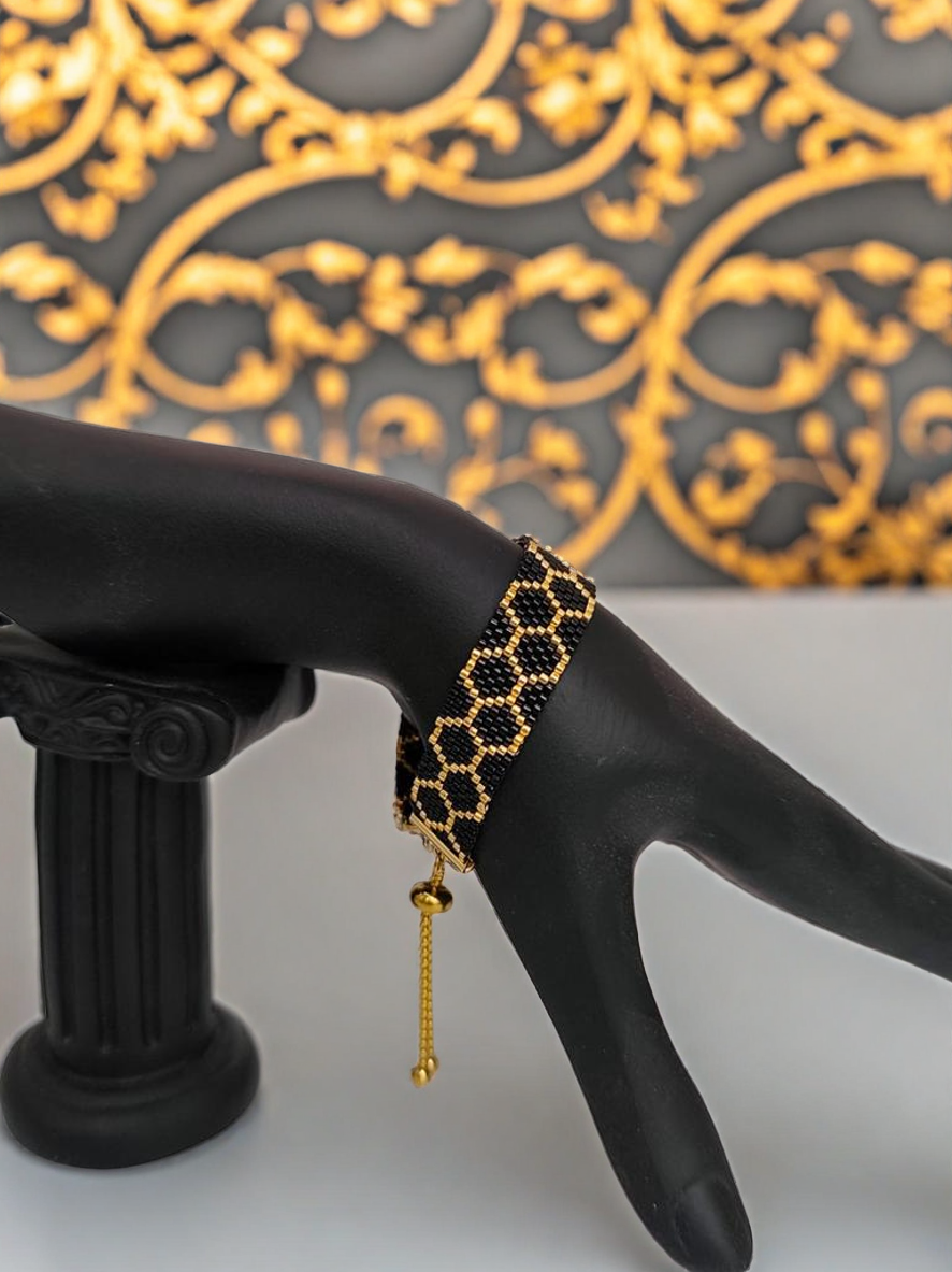 Bracelet tissé avec 800 perles noires et dorées .