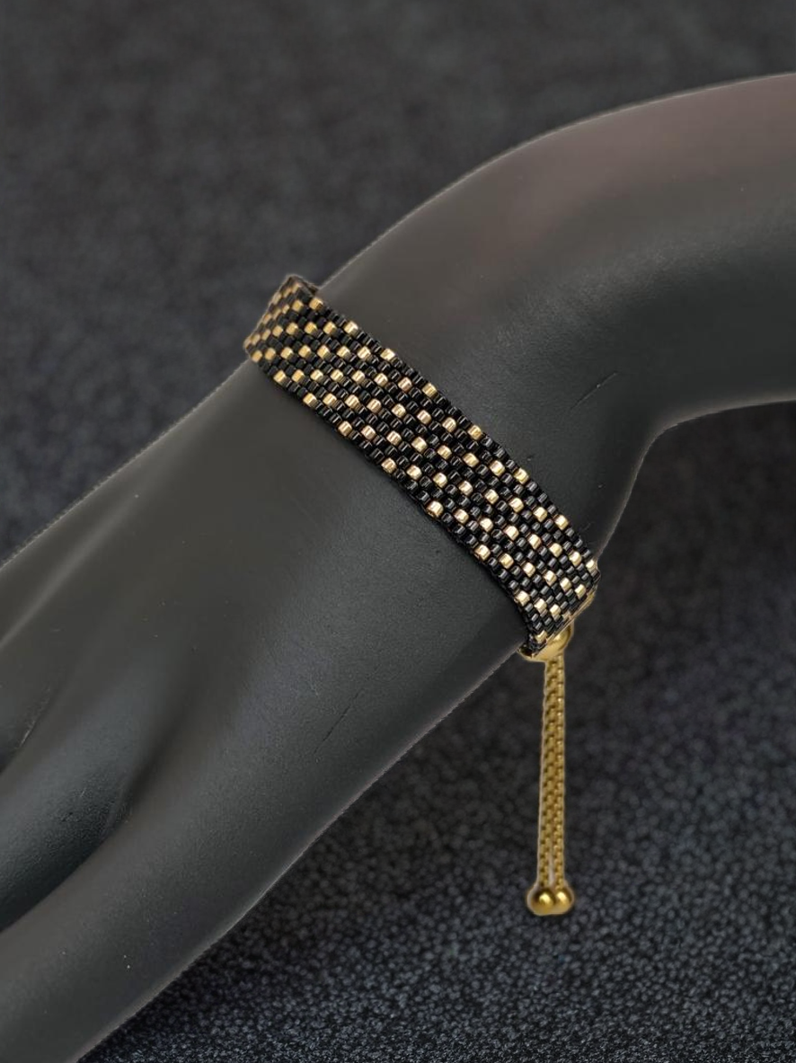Bracelet tissé avec 640 perles noires et dorées .