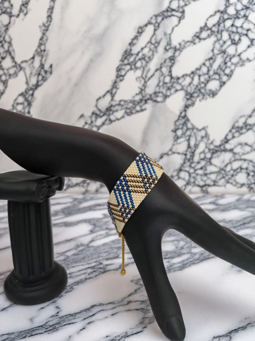 Bracelet tissé avec 1120 perles bleues crème et bronze .