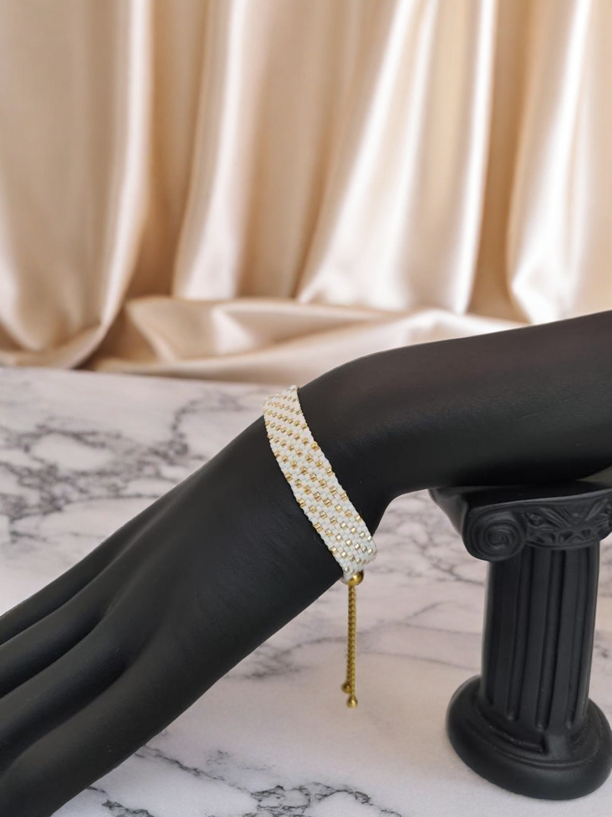 Bracelet tissé avec 640 perles blanches et dorées .