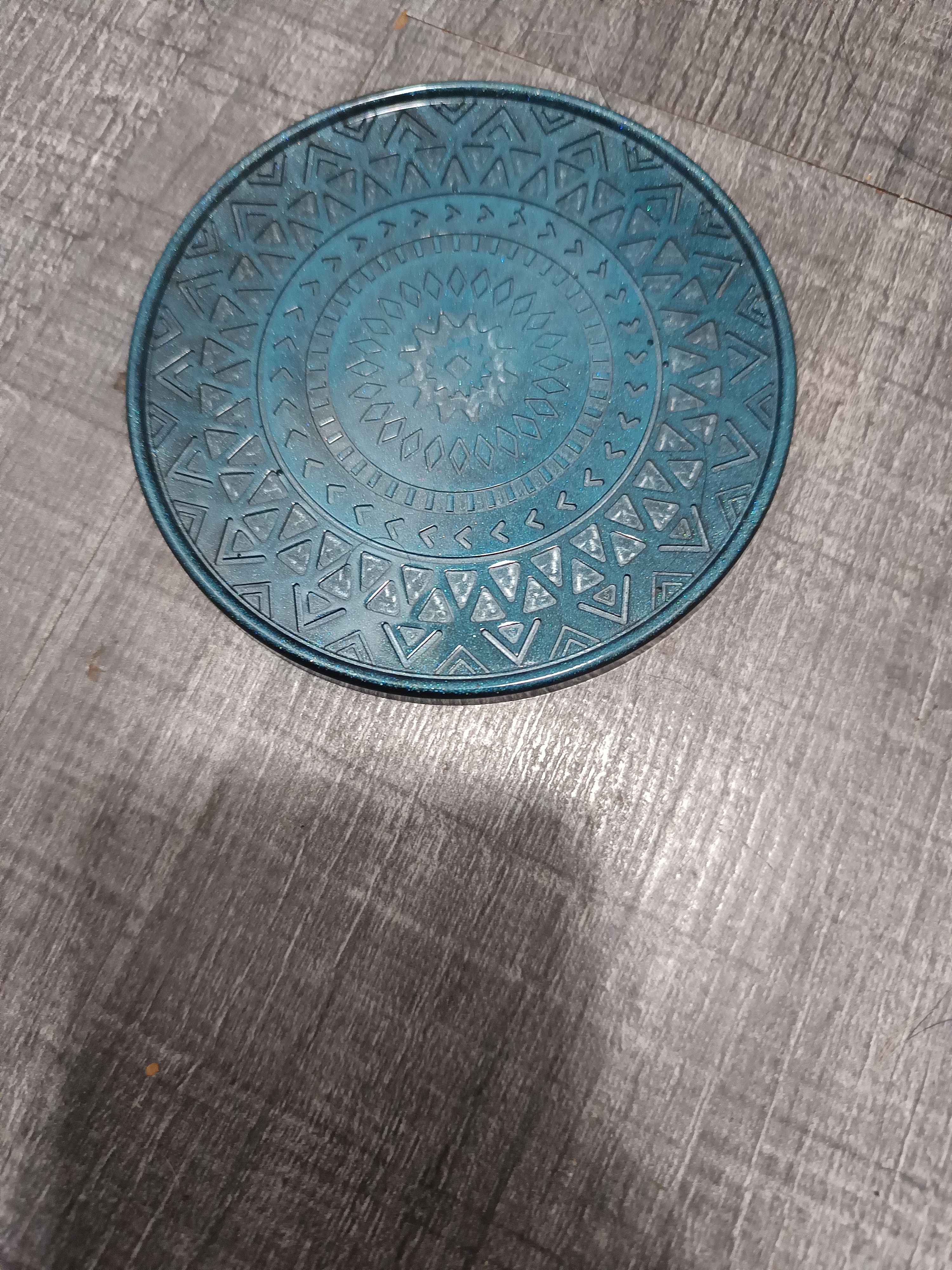 Dessous de verre bleu turquoise et noir orné de motifs de mandala. En résine époxy artisanale entièrement fait main en France et pièce unique.