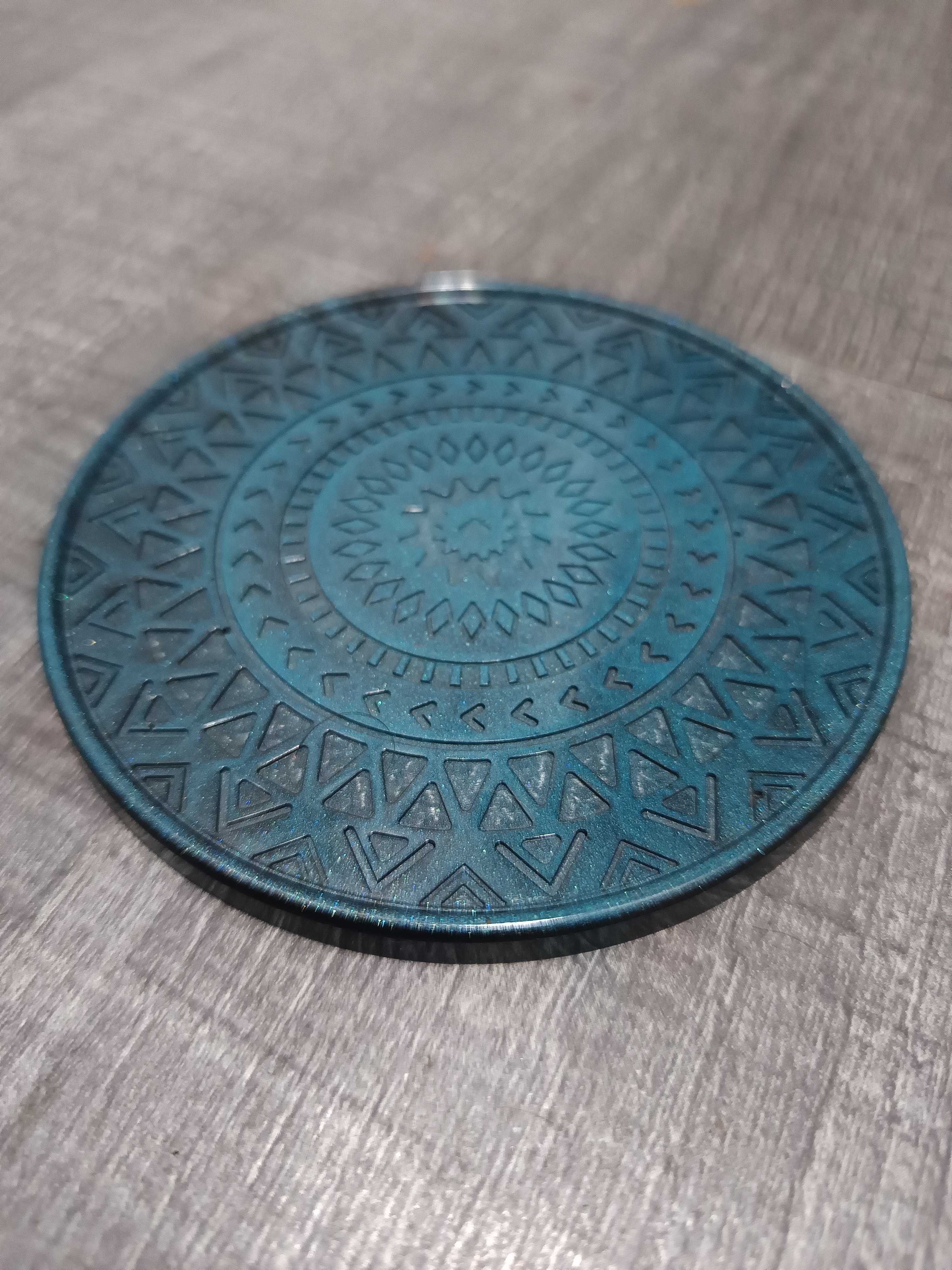 Dessous de verre bleu turquoise et noir orné de motifs de mandala. En résine époxy artisanale entièrement fait main en France et pièce unique.