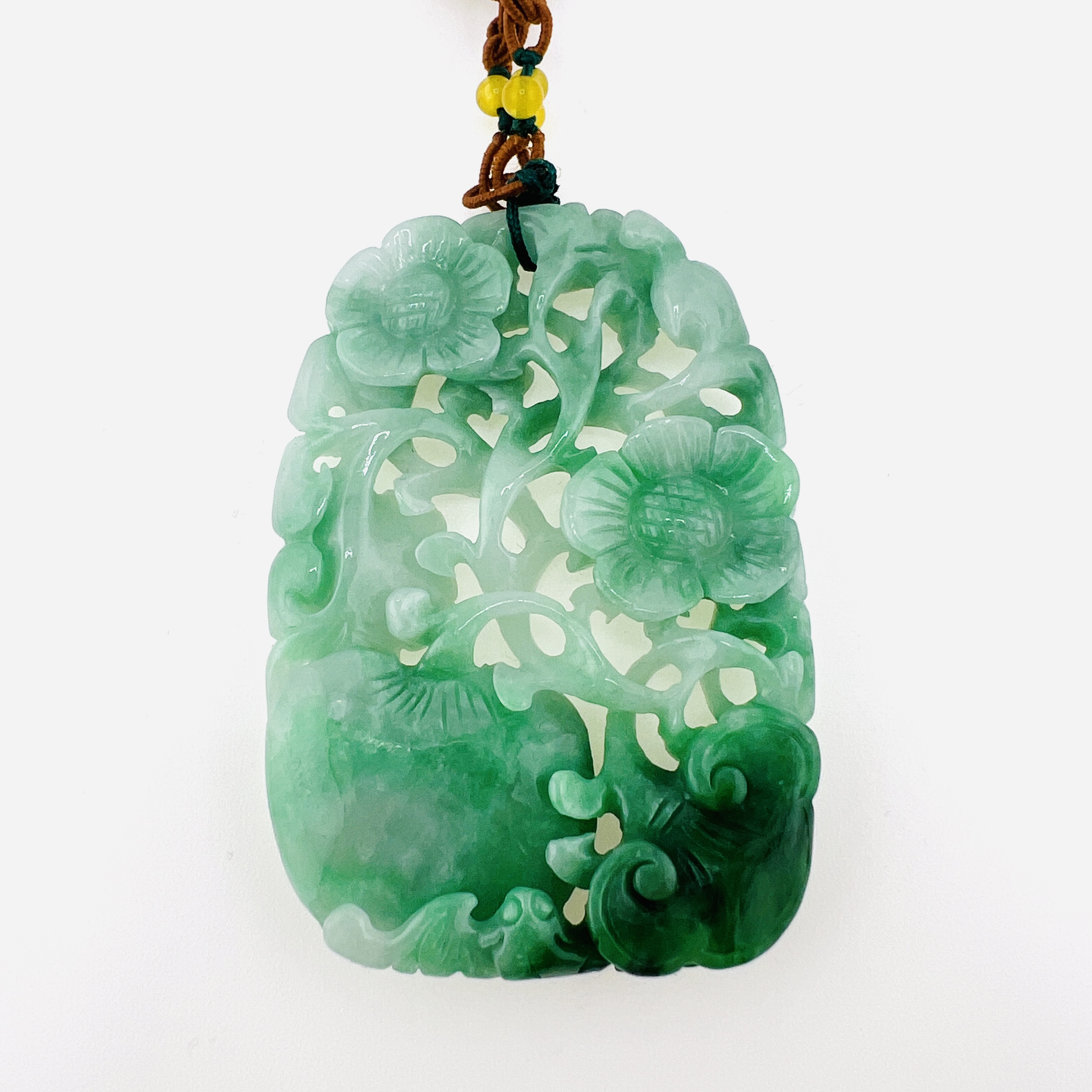 Natural green jadeite pendant necklace with double sided carving of flowers, Ruyi, and peach