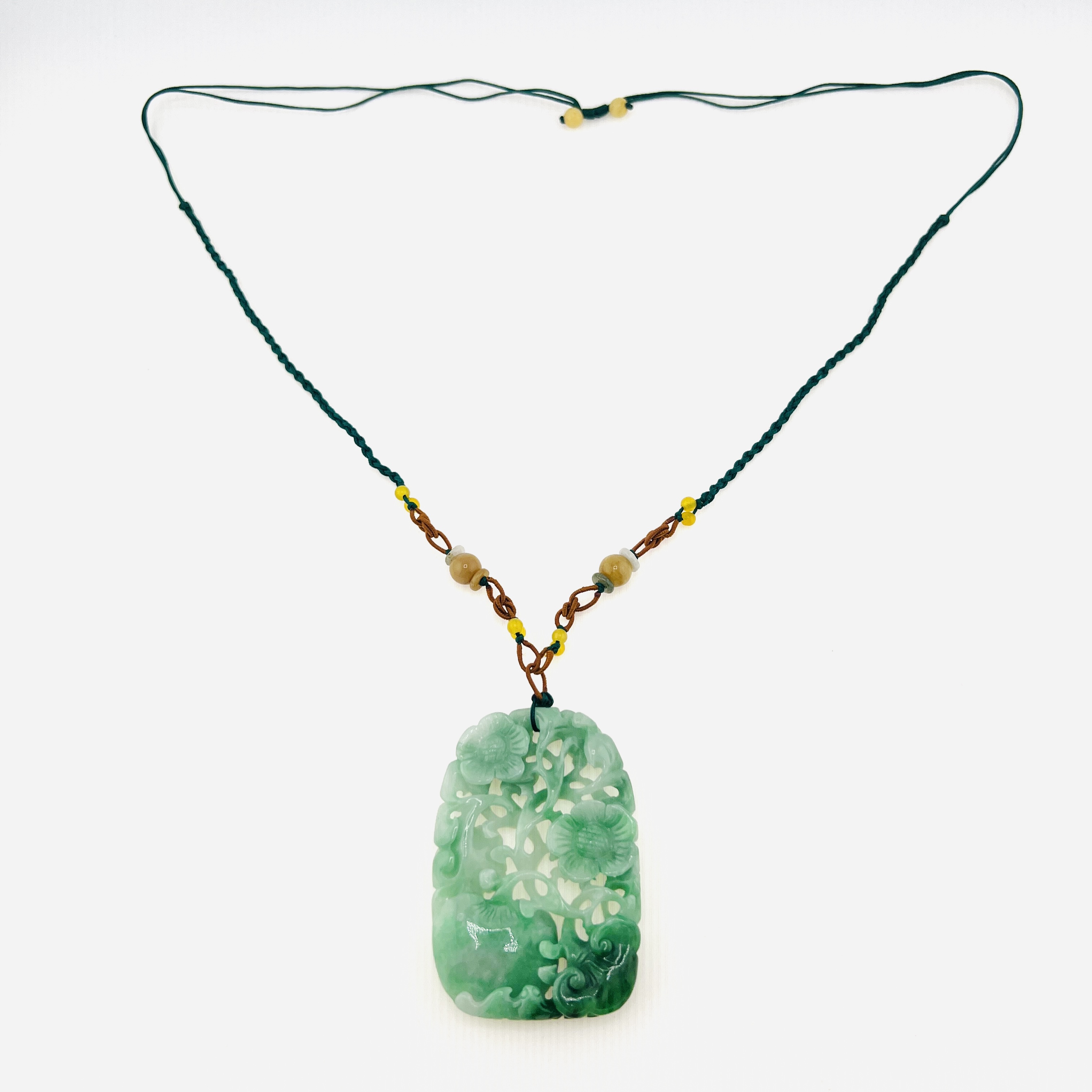 Natural green jadeite pendant necklace with double sided carving of flowers, Ruyi, and peach