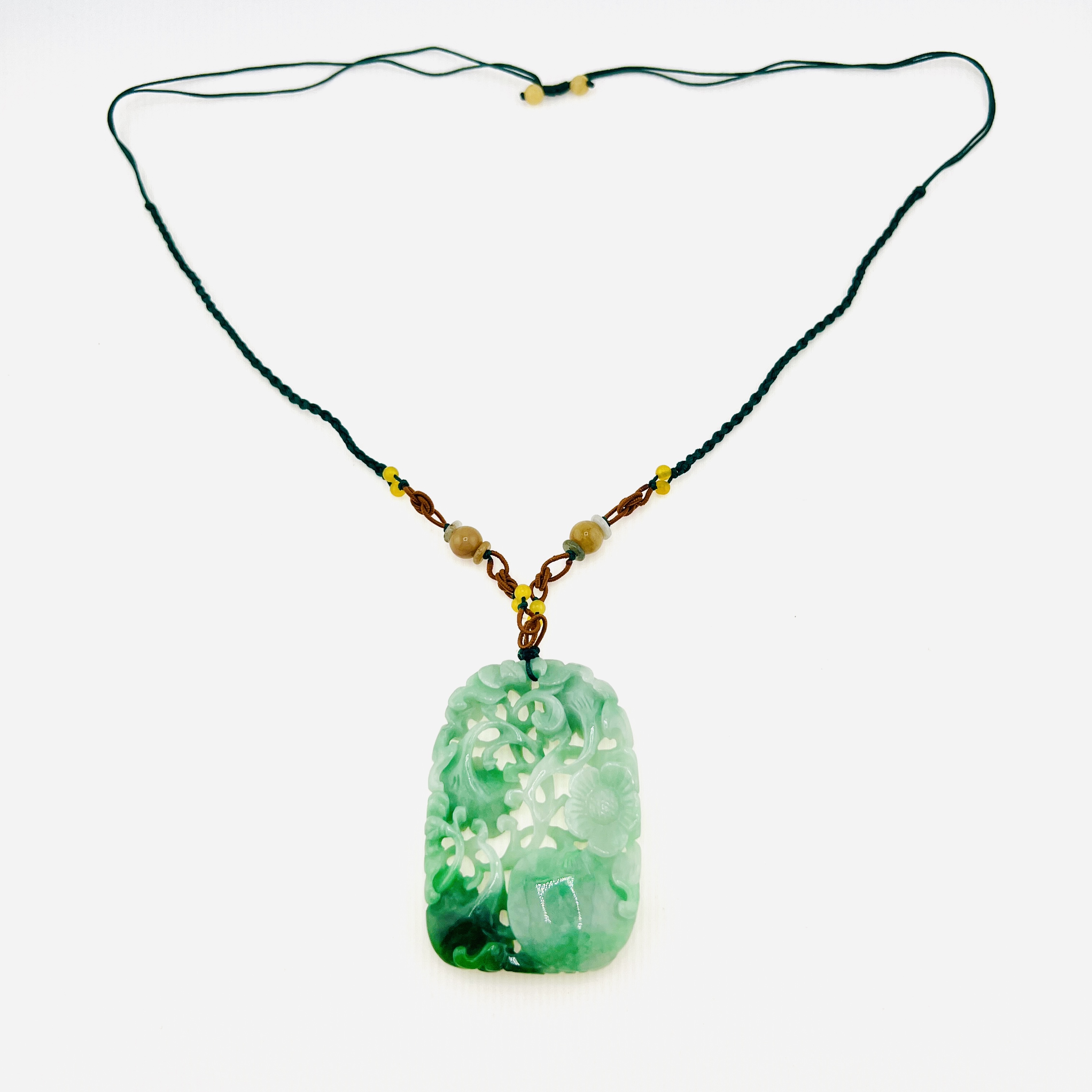 Natural green jadeite pendant necklace with double sided carving of flowers, Ruyi, and peach