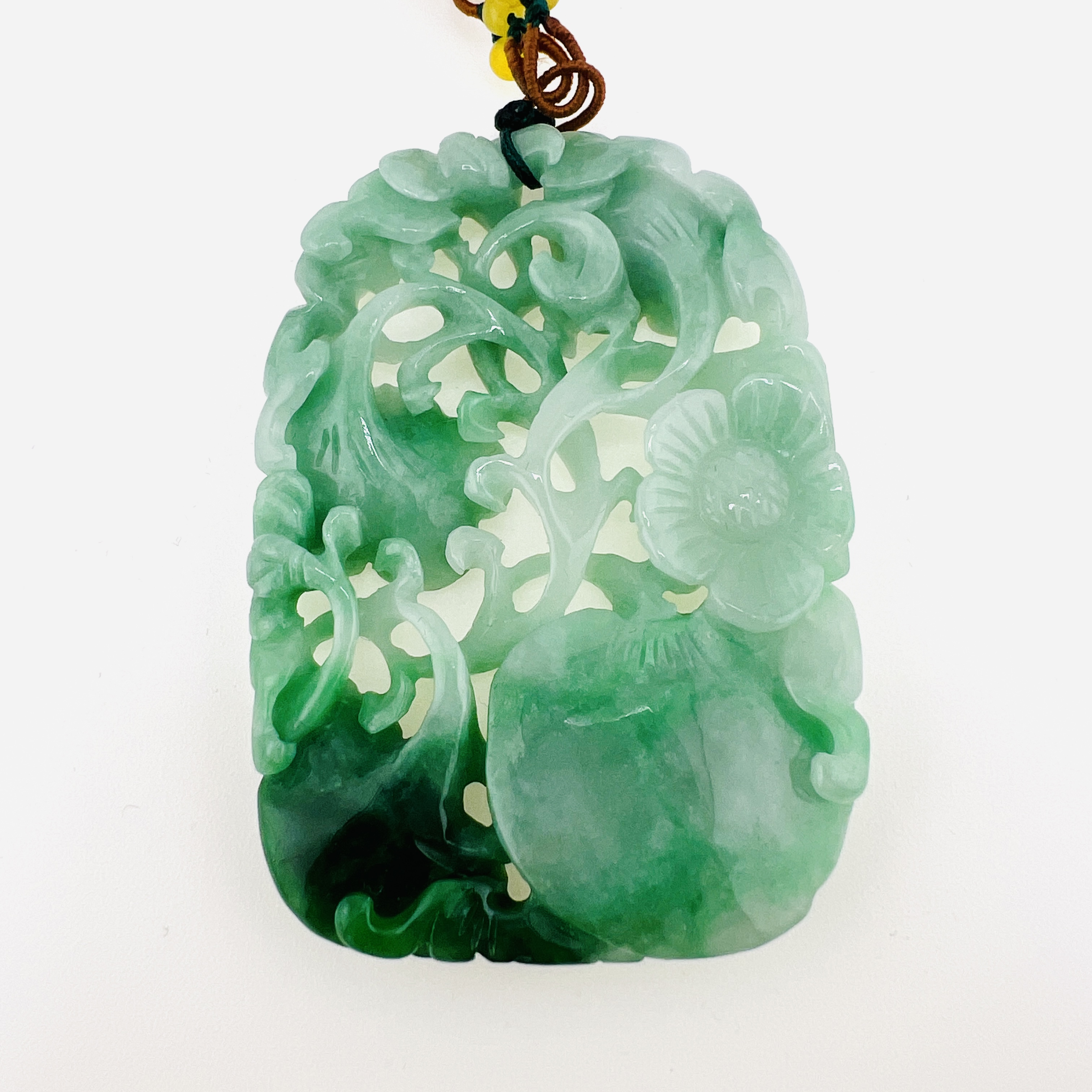Natural green jadeite pendant necklace with double sided carving of flowers, Ruyi, and peach