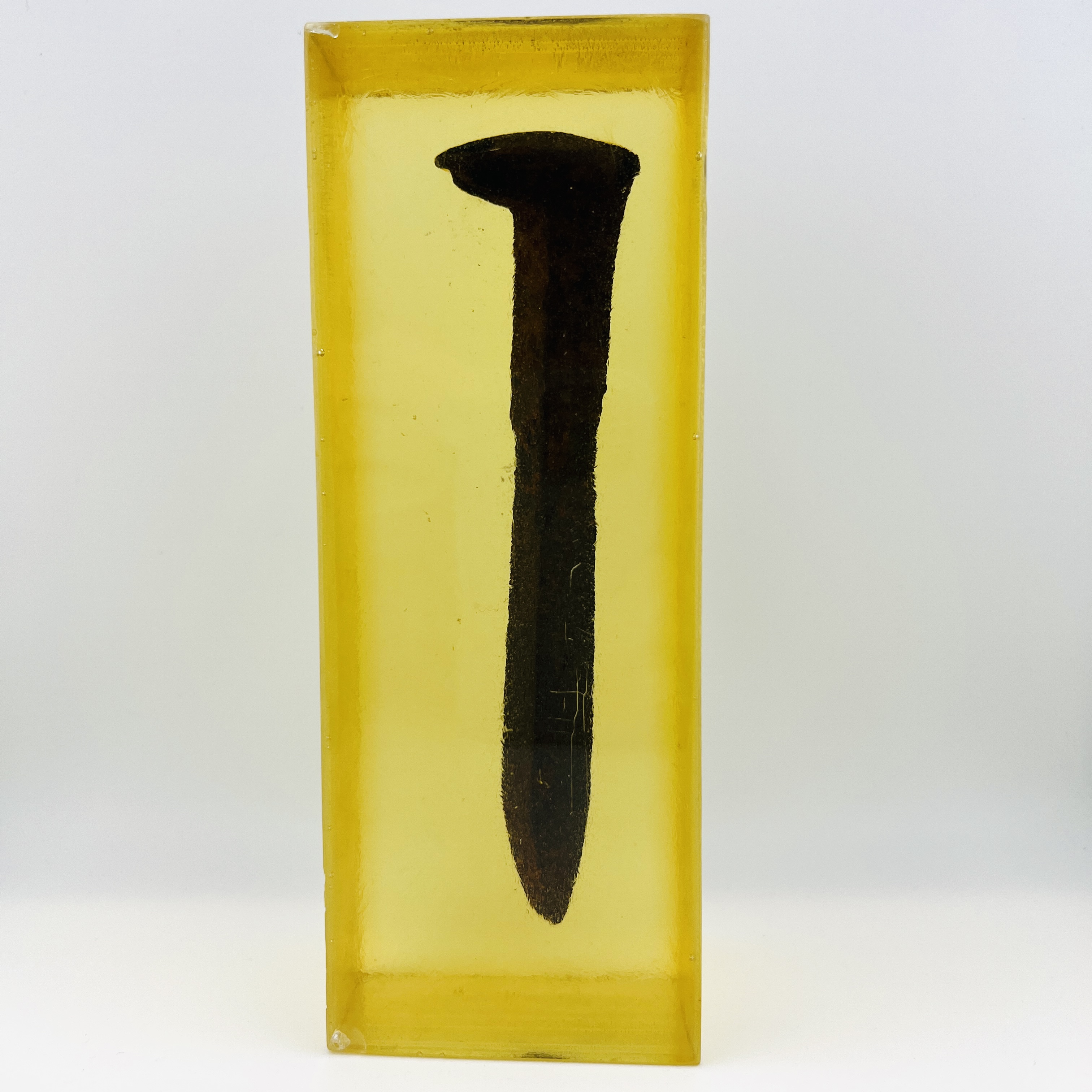 Original Pacific Coast railroad steel spike resin display block in amber color