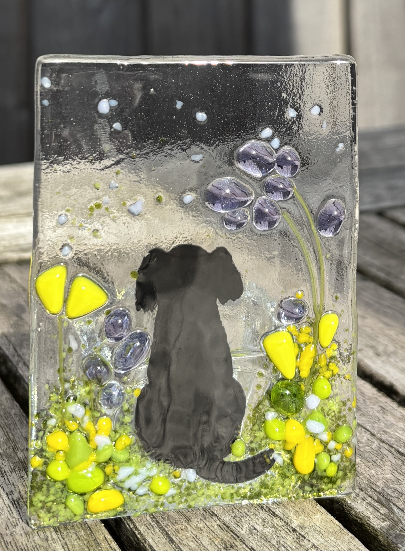 Black dog silhouette with yellow and lilac flowers