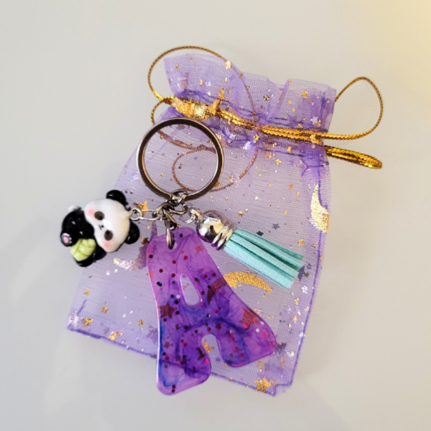 Llavero de letra con colores y purpurina; con 2 acesorios y bolsita regalo.