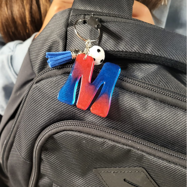 Llavero de letra con colores y purpurina; con 2 acesorios y bolsita regalo. 