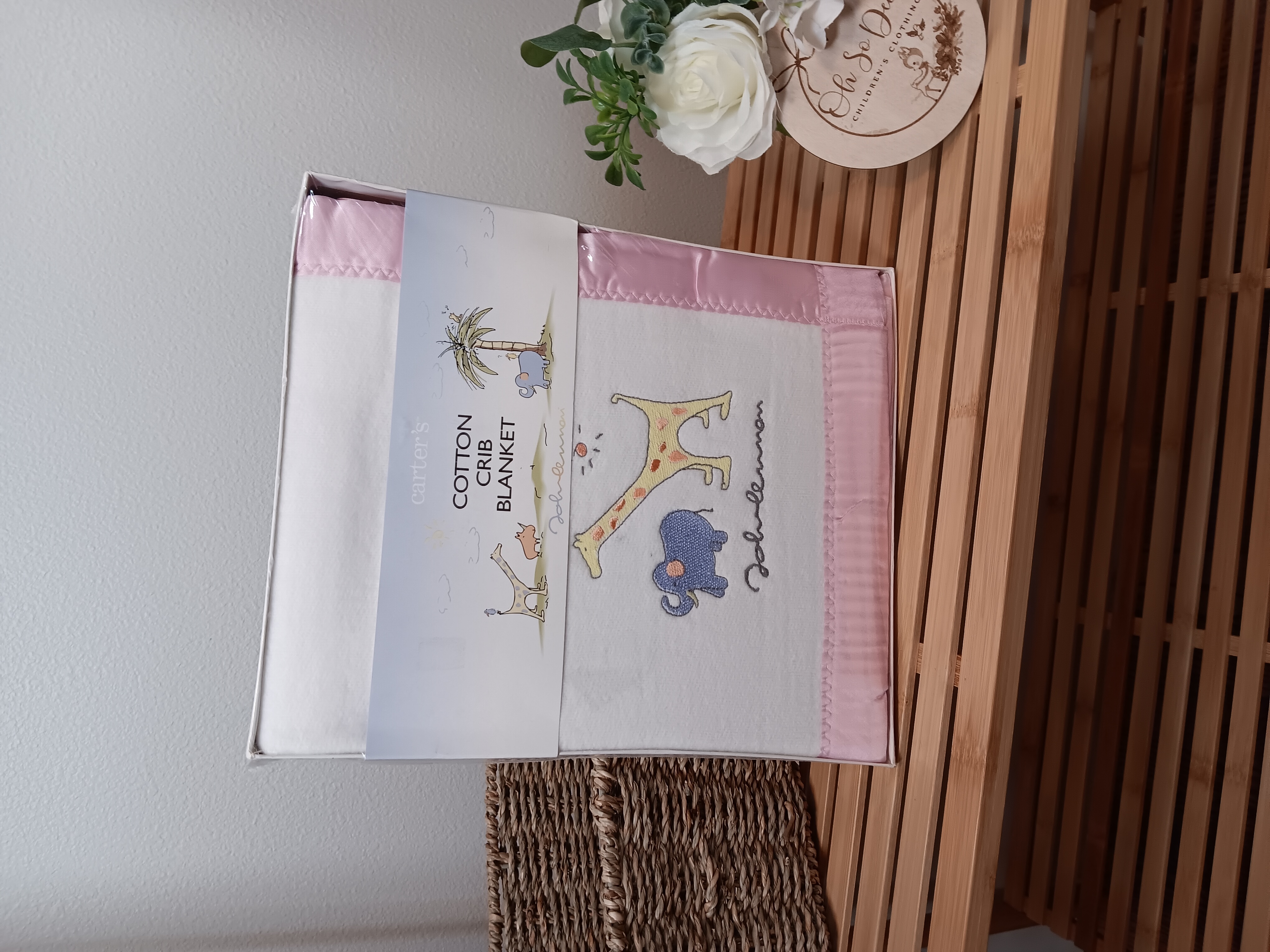 White John Lennon cotton crib blanket with pink satin trim 