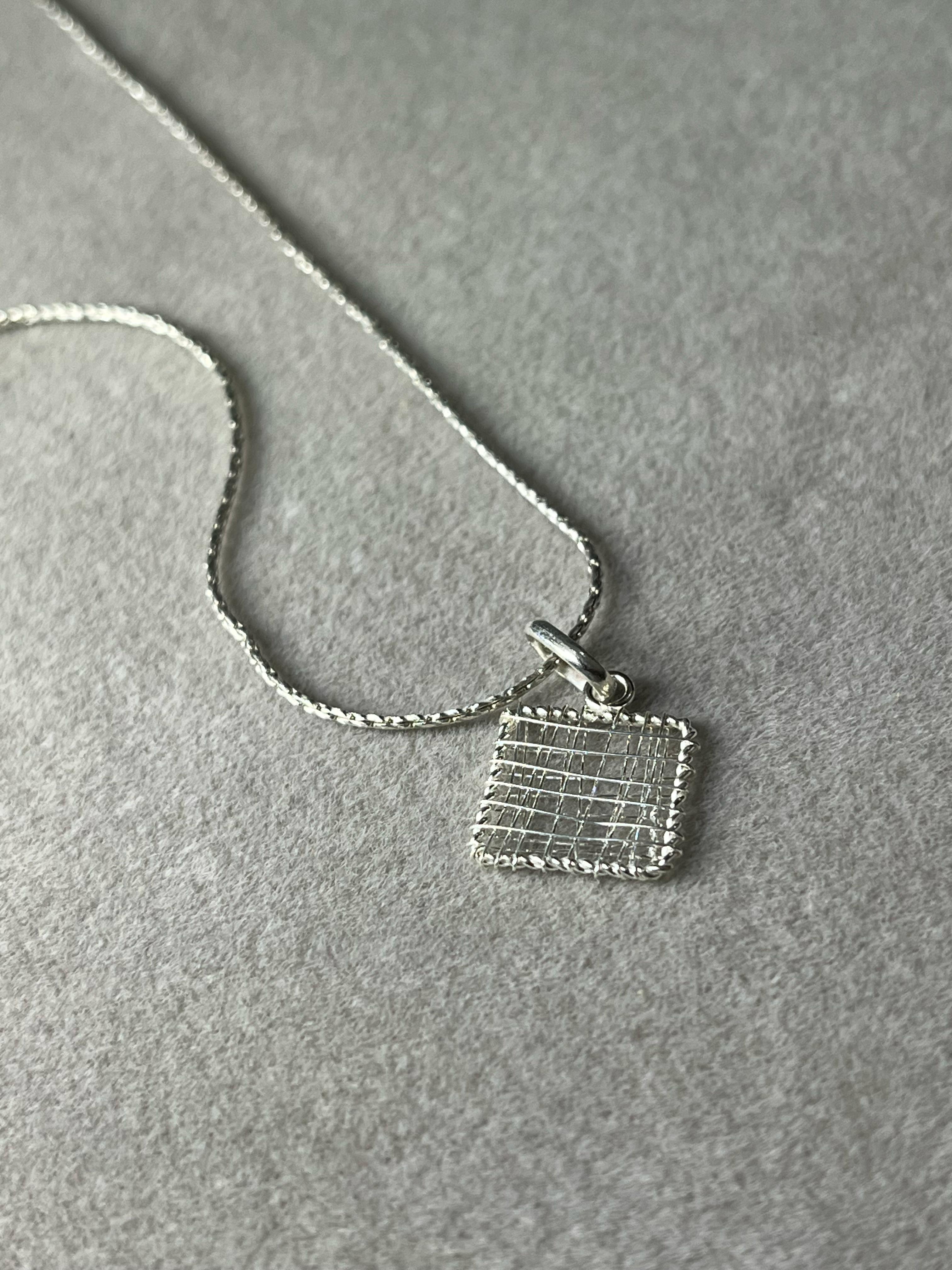 Dije cuadrado con hilos de plastico