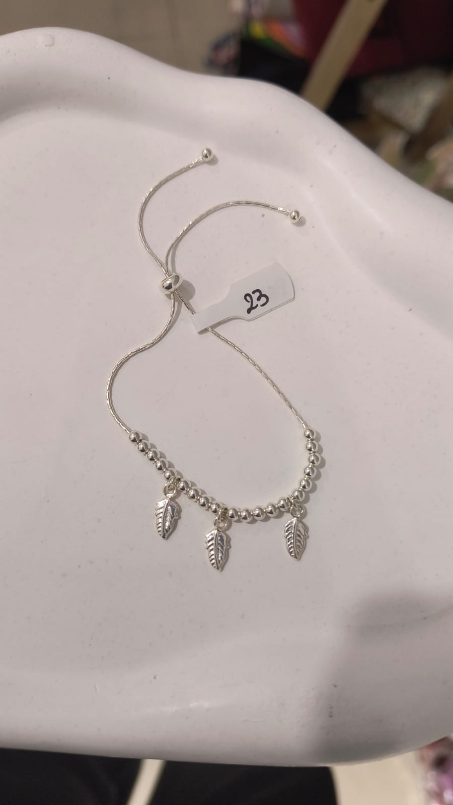 Pulserita regulable con dijes pluma y bolitas