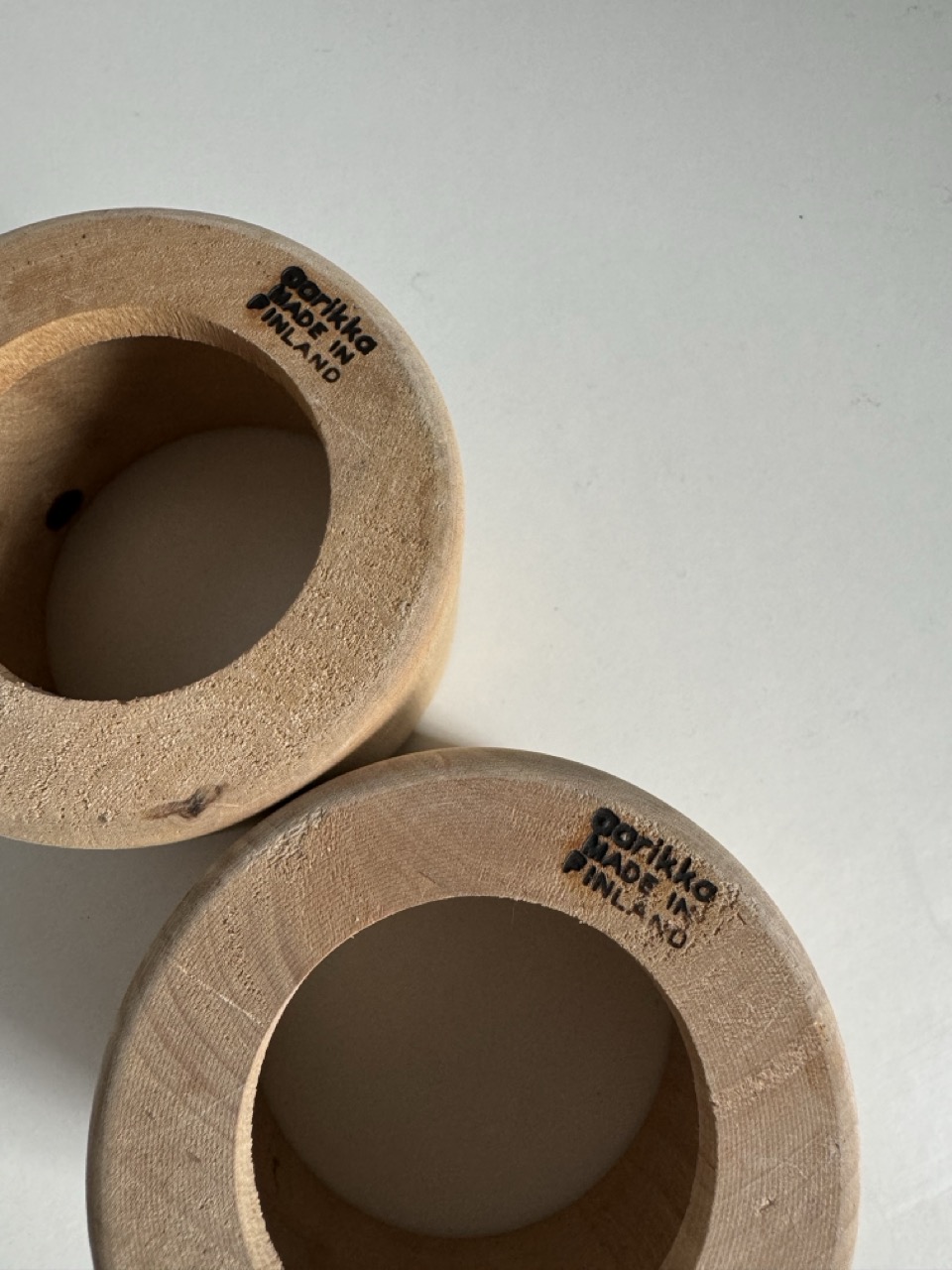 A pair of glass cups with handmade wooden coasters by the Finnish brand Aarikka