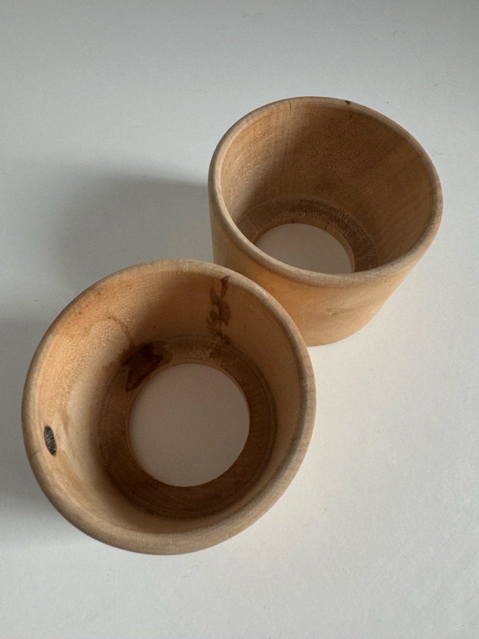 A pair of glass cups with handmade wooden coasters by the Finnish brand Aarikka