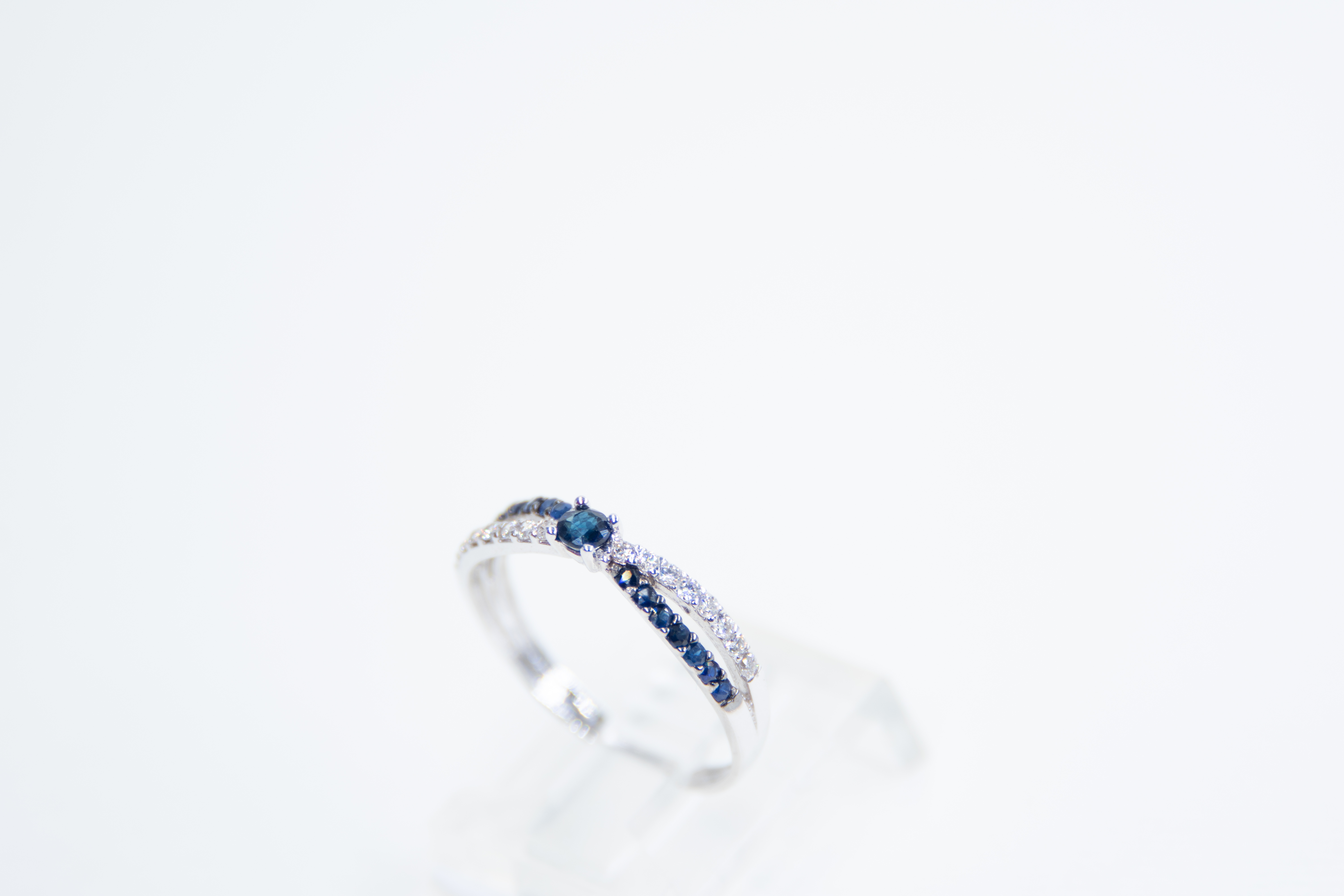 Anillo de plata con piedras azules y blancas.