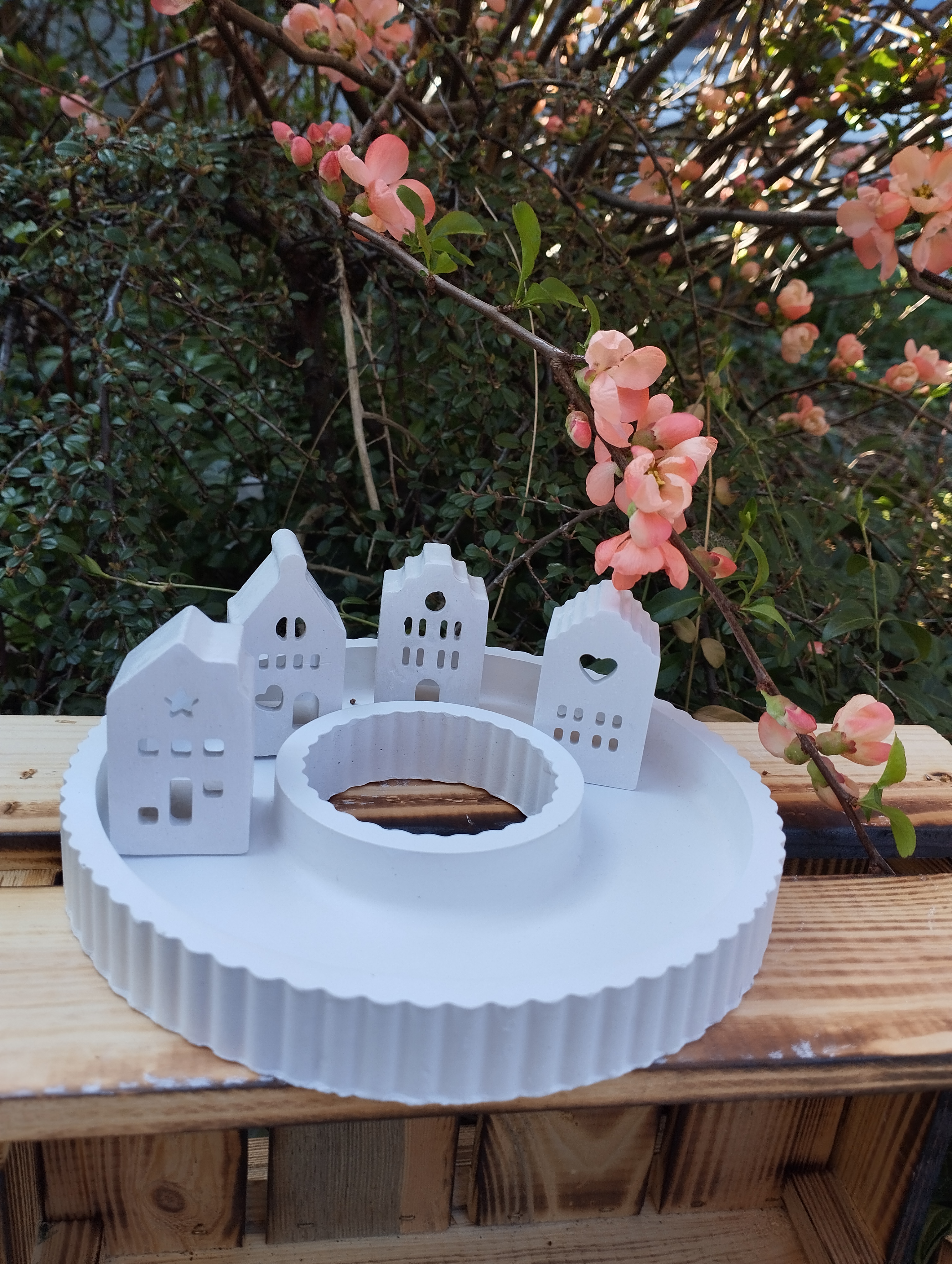 kleines Häuser Dorf auf runden Tablett mit Kerzenhalter