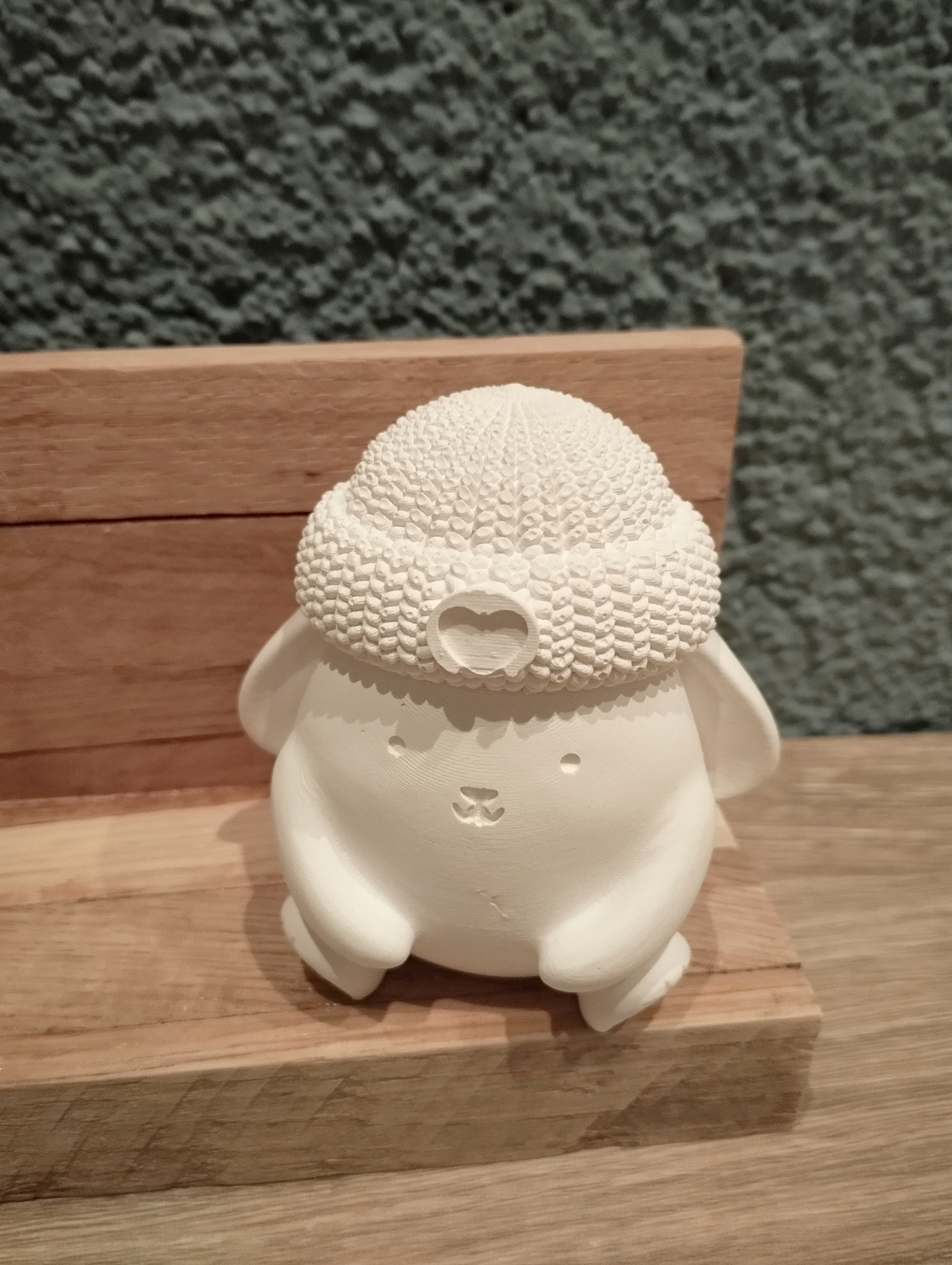 Arrangement Hase mit Strickmütze und Kerzenhalter auf Holzbank