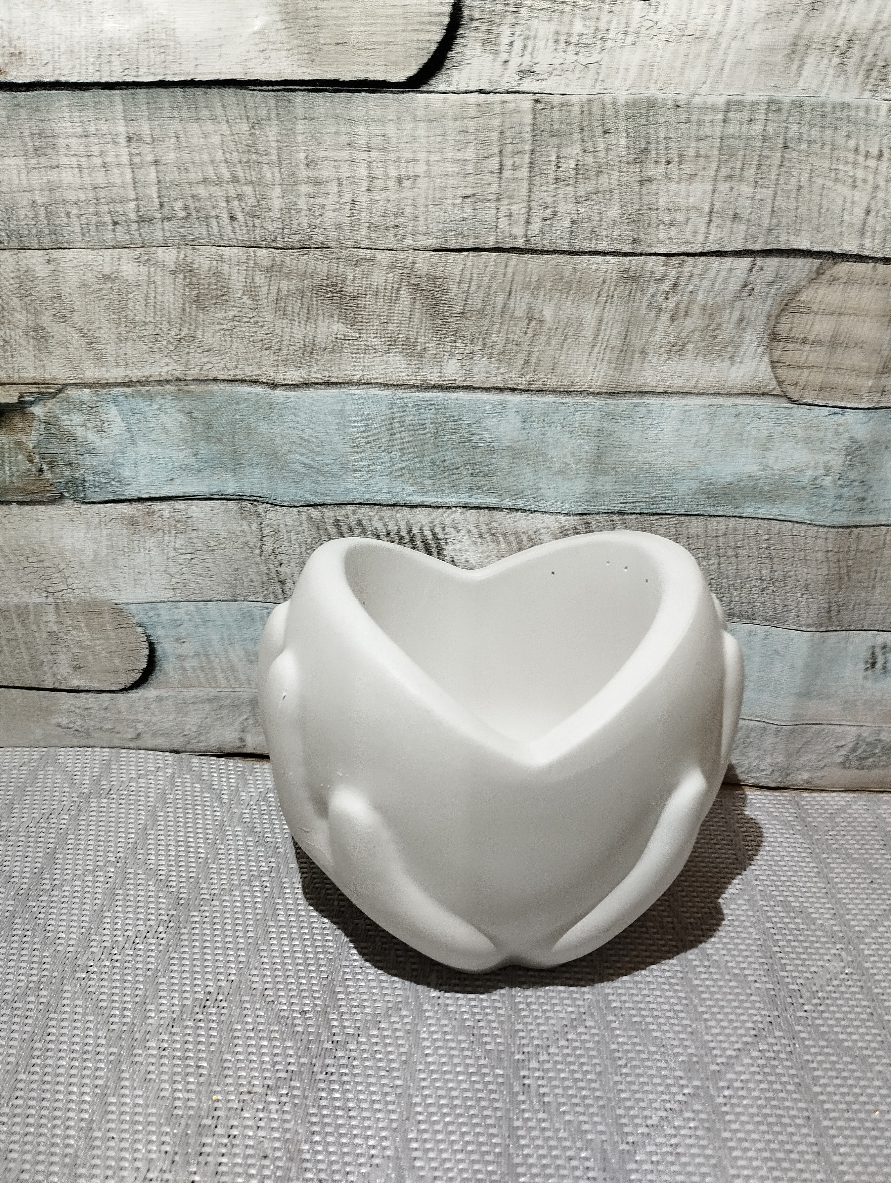 Weiße Herzförmige Schale mit Händen